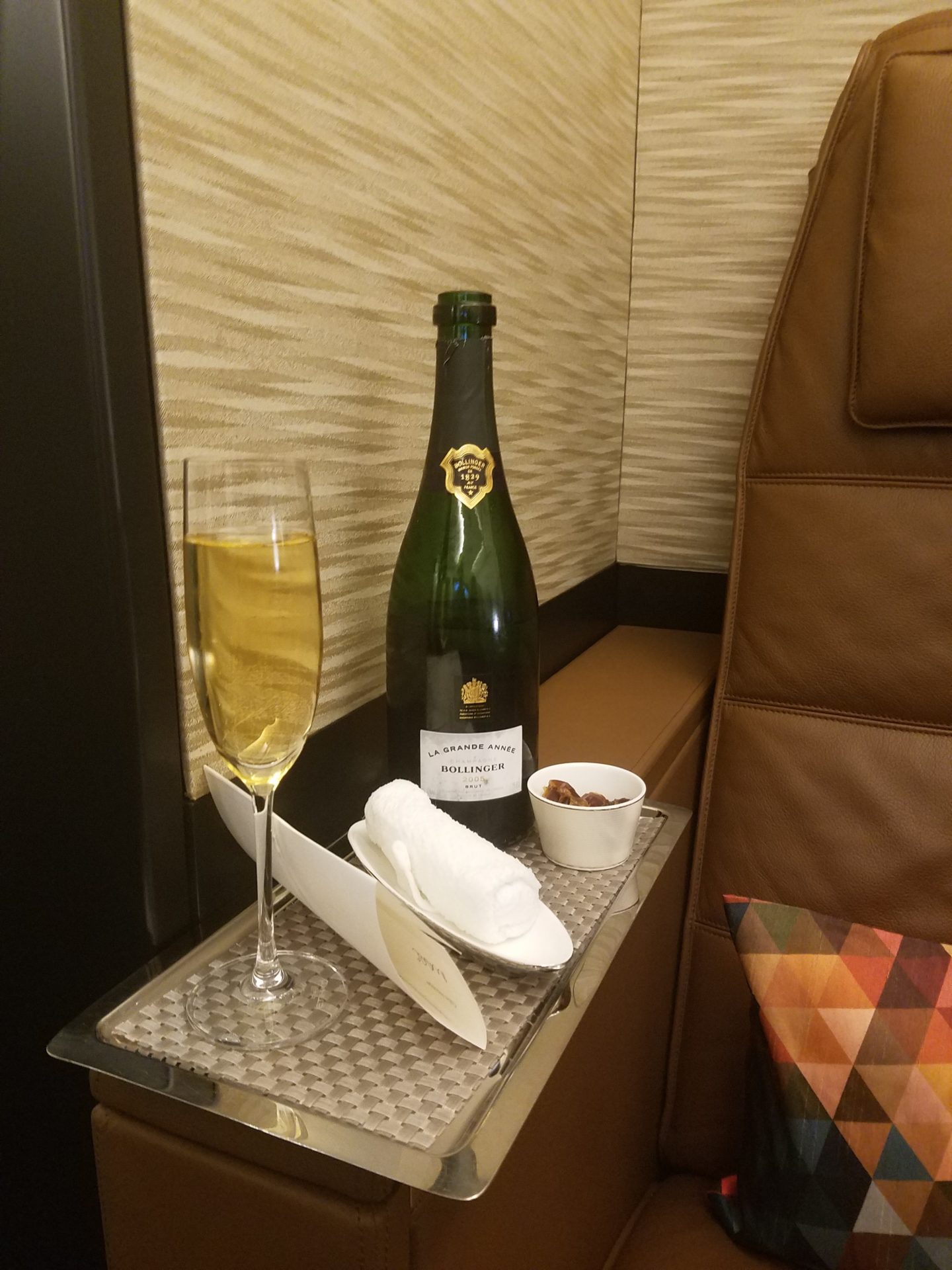 a glass of champagne and a bottle on a tray
