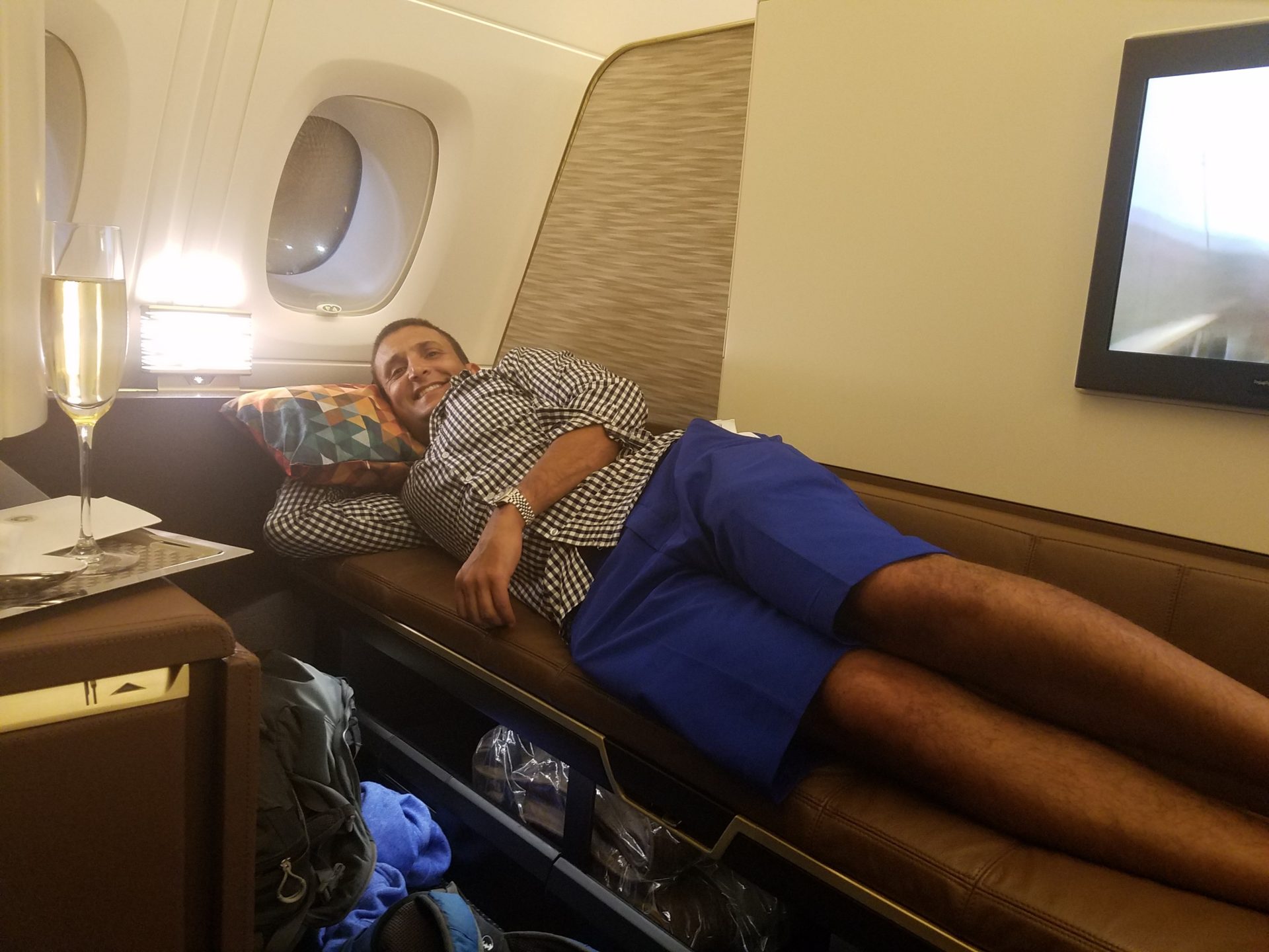 a man lying on a couch in an airplane
