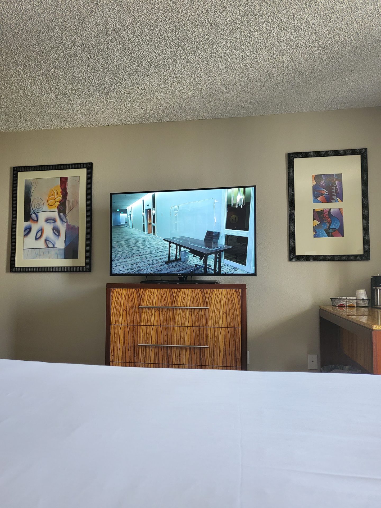 a bedroom with a television and pictures on the wall