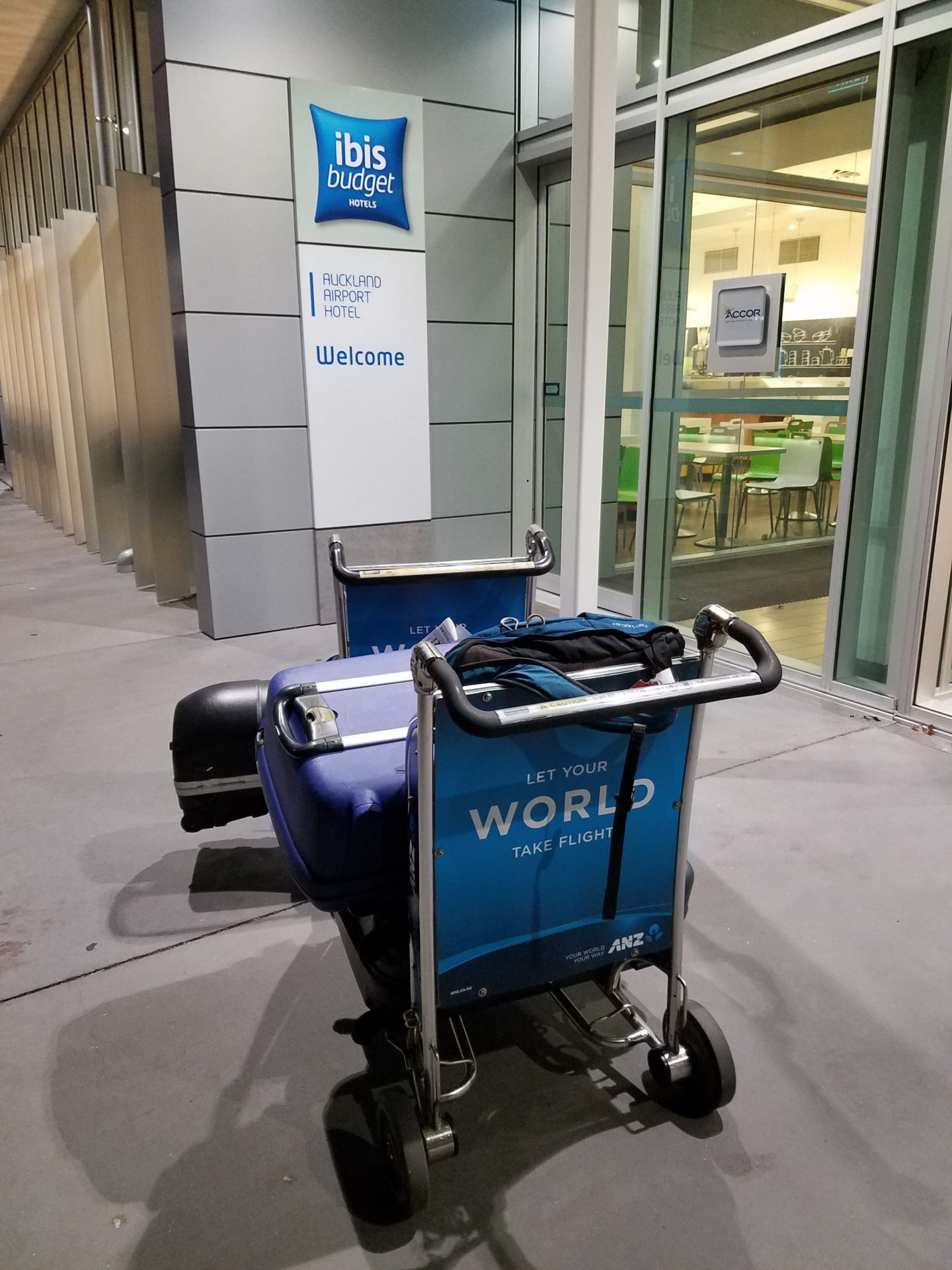 a blue luggage cart in front of a building