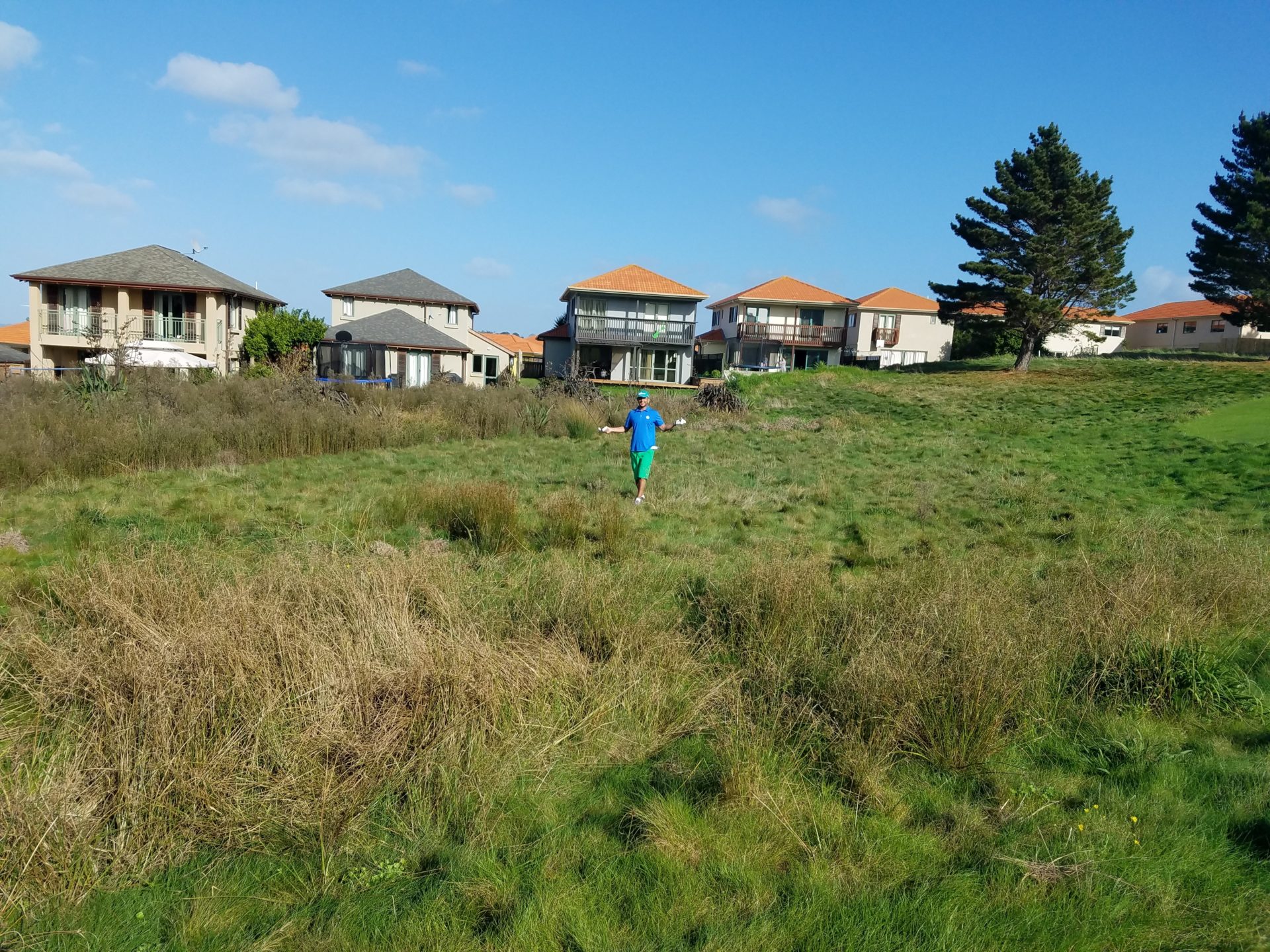a person in a field with houses in the background