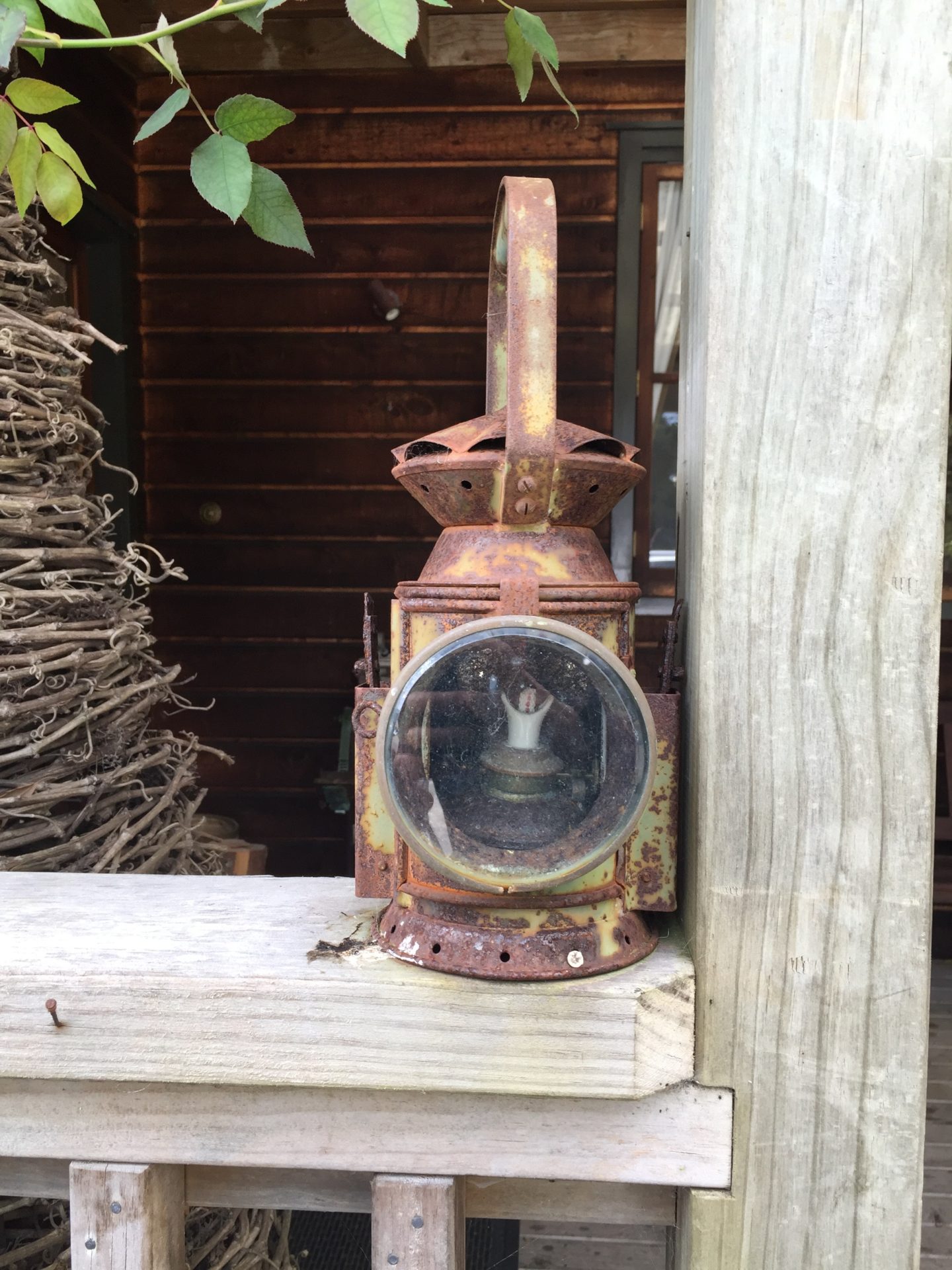 a rusty lantern on a wooden post