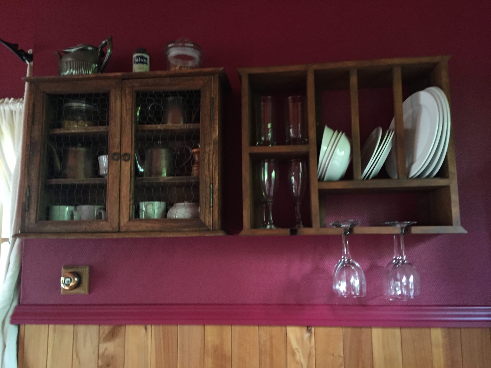 a wooden cabinets with plates and glasses on a wall