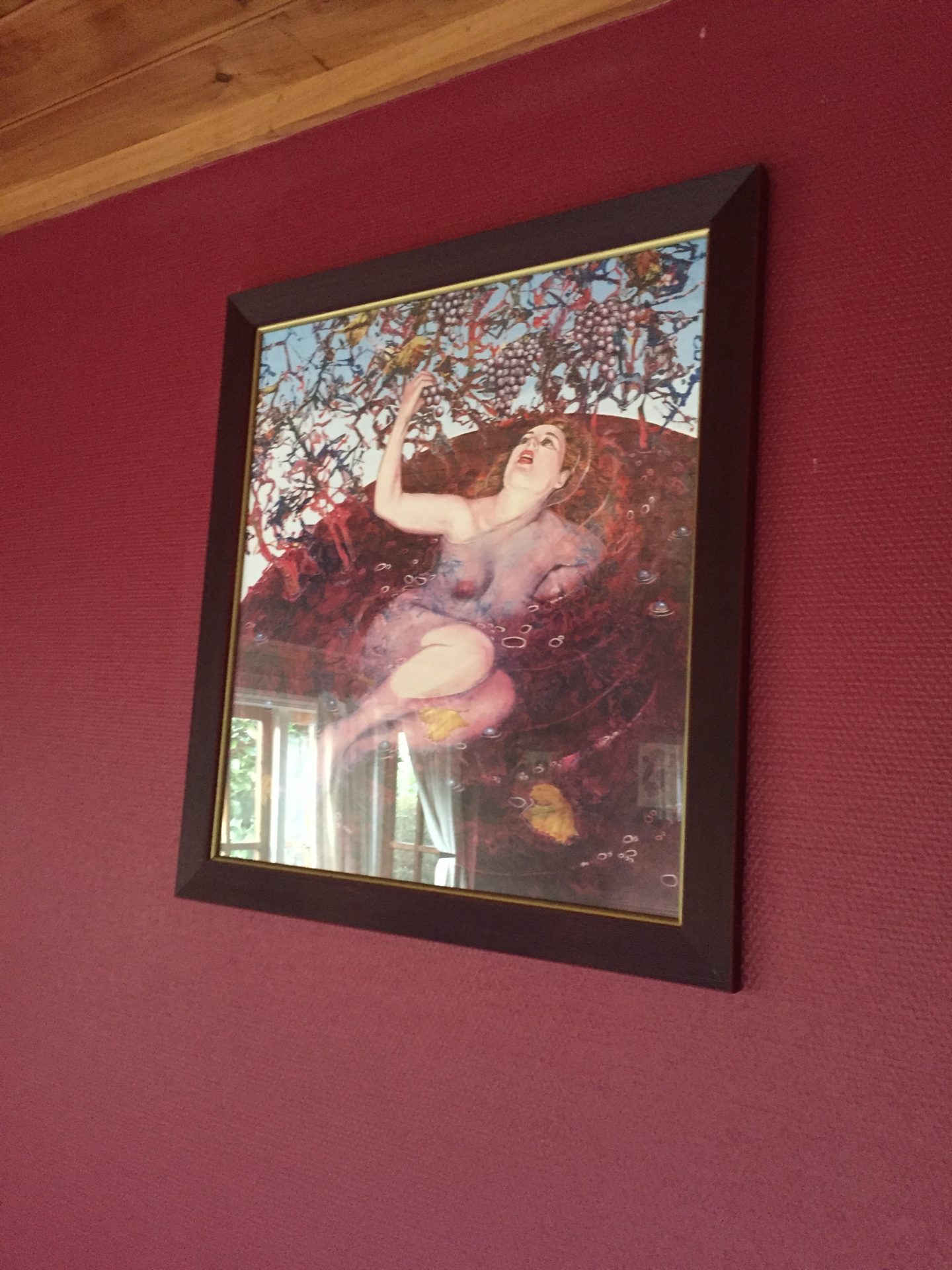 a framed picture of a woman on a red wall