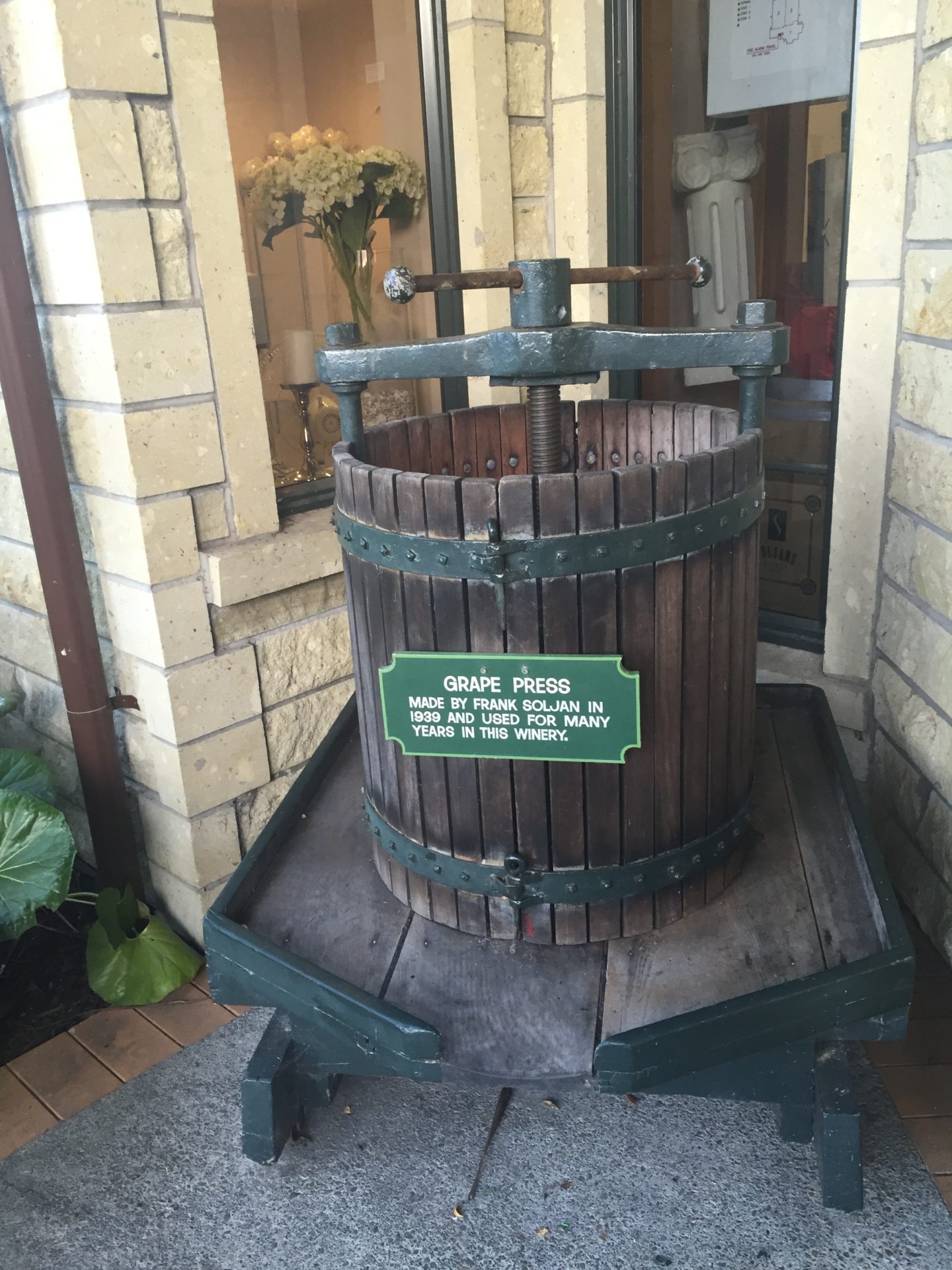 a wooden wine press with a sign on it
