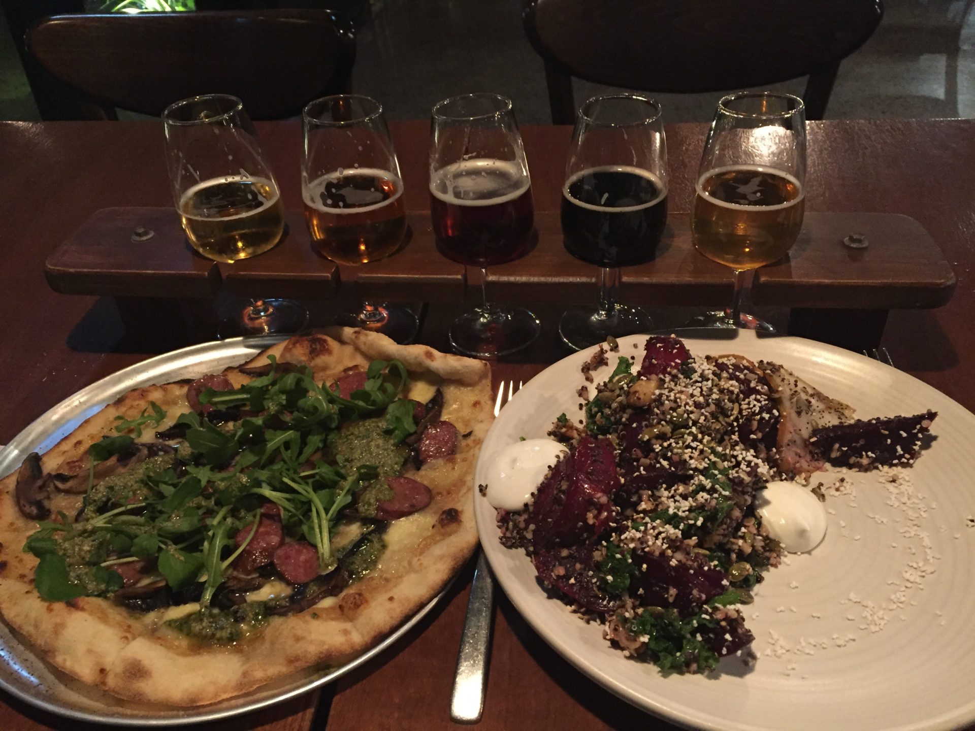 a plate of food and glasses of beer on a table