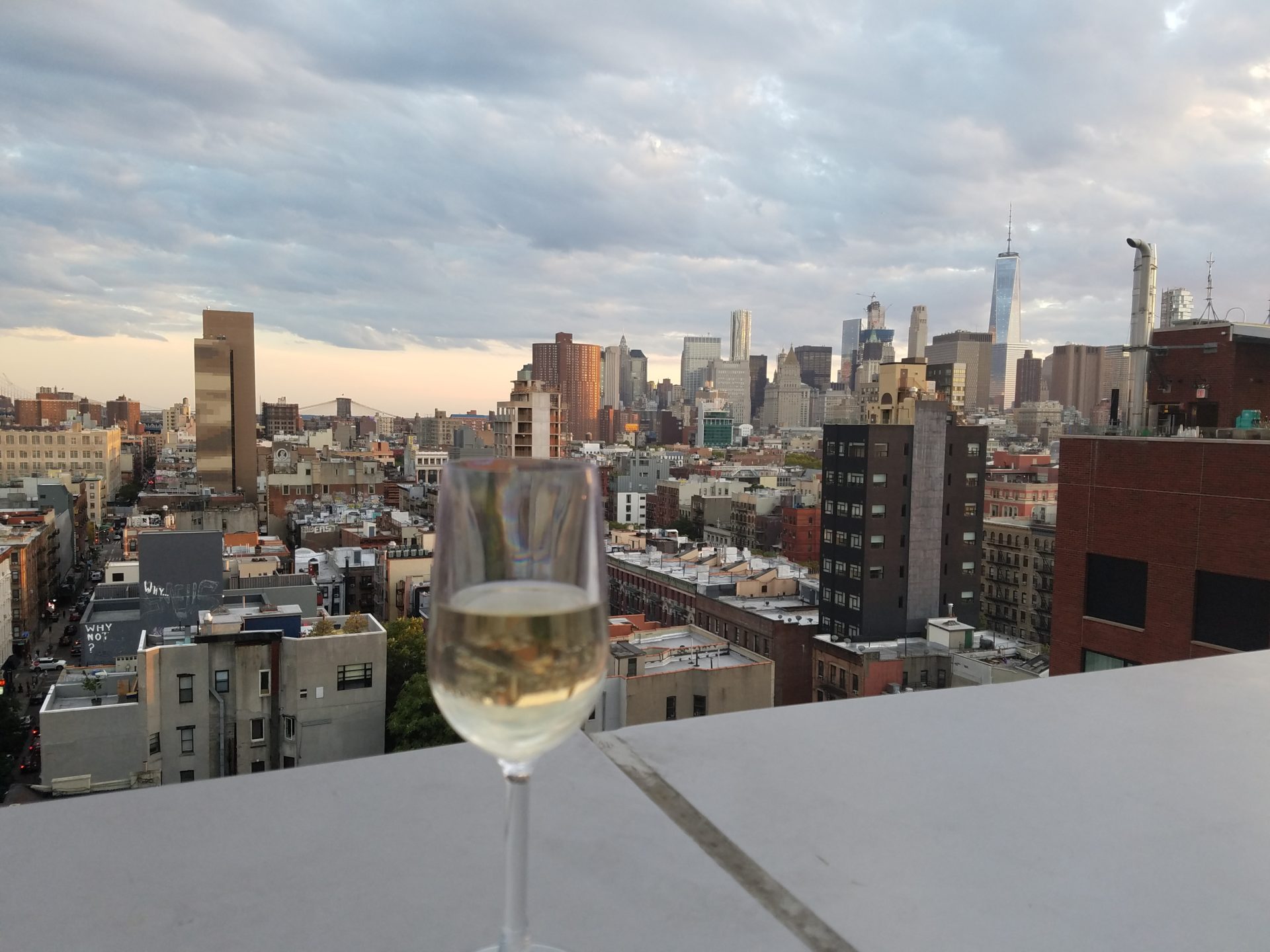 a glass of wine on a table with a city in the background