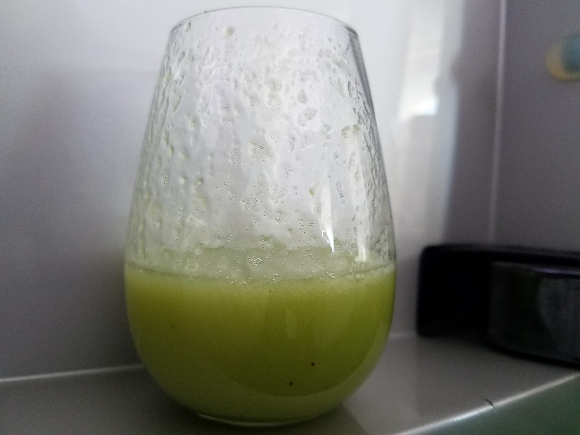 a glass with a green liquid in it