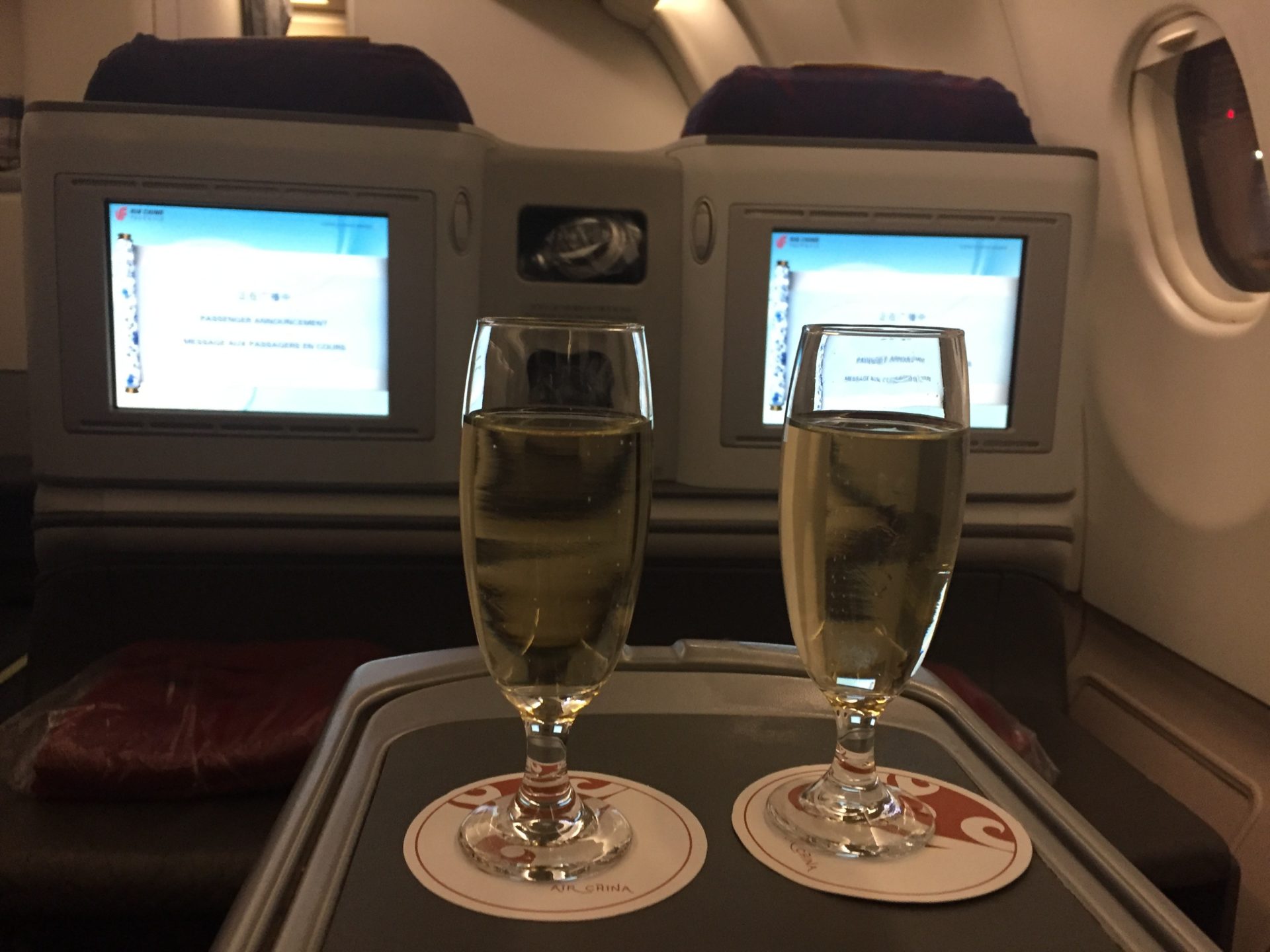 two glasses of champagne on a tray in front of a television