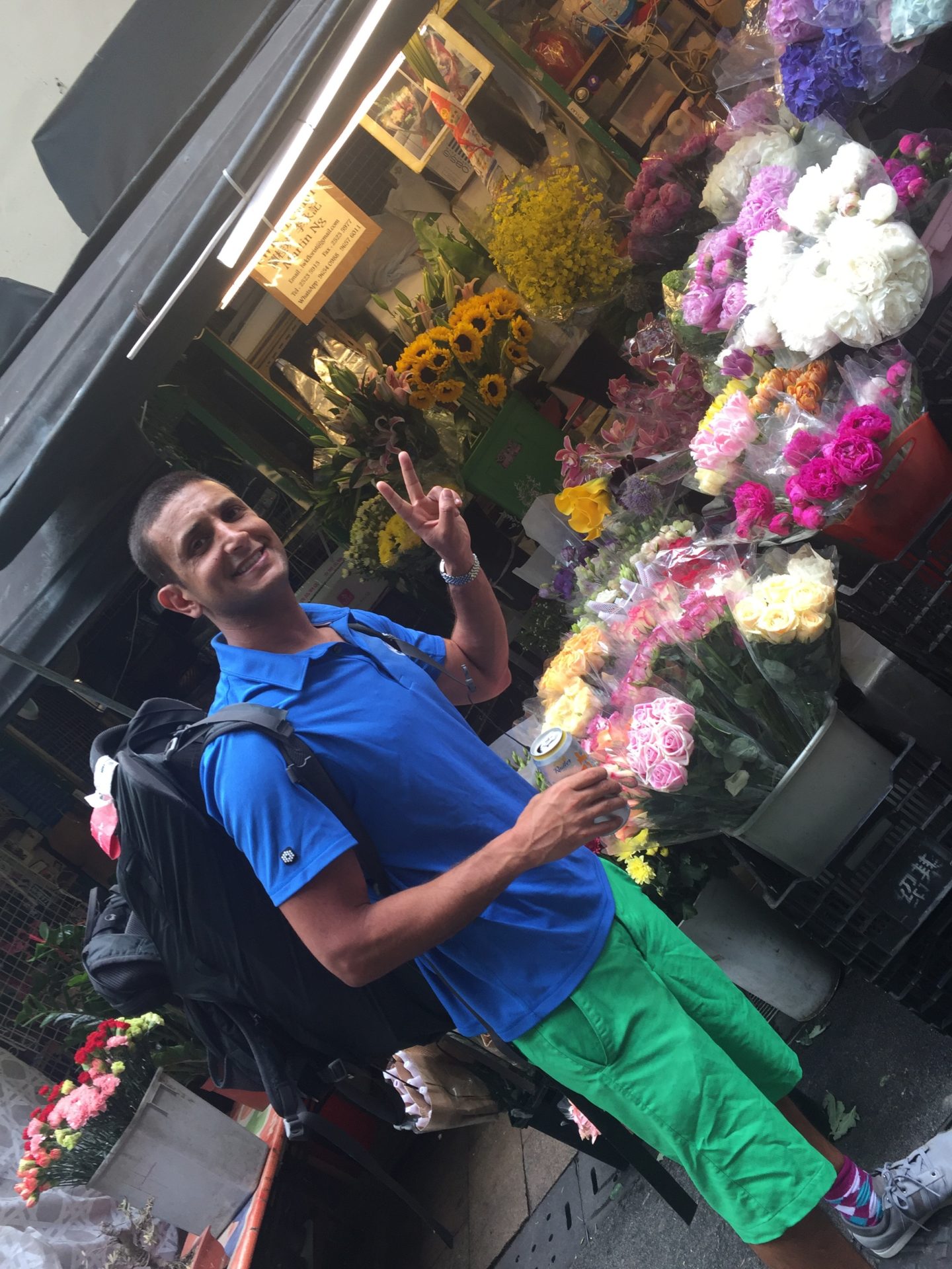 a man standing in front of a bunch of flowers