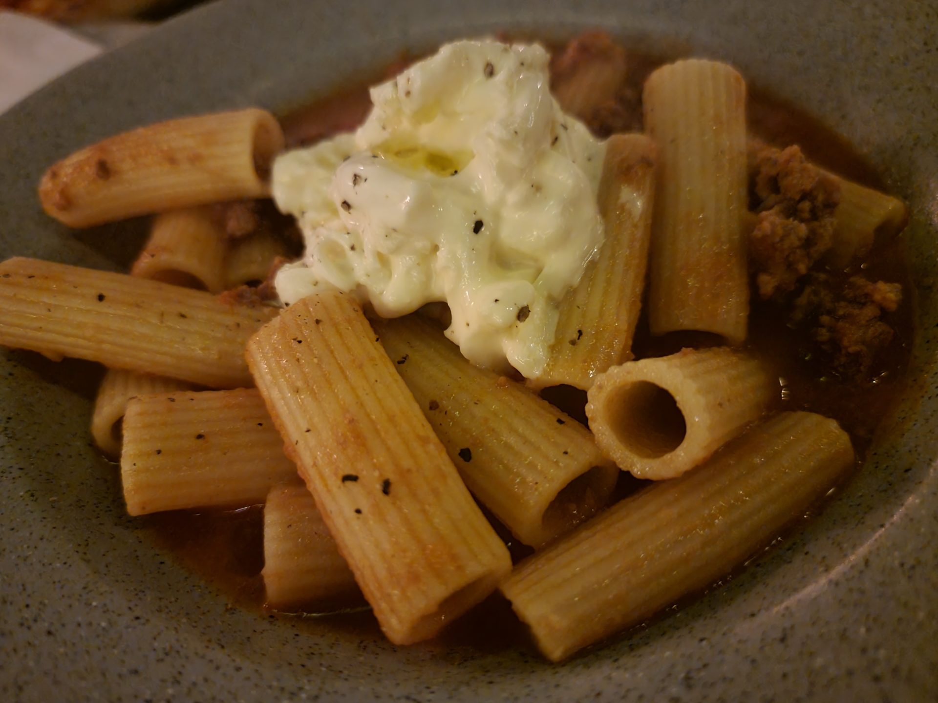 a plate of pasta with sauce and sour cream