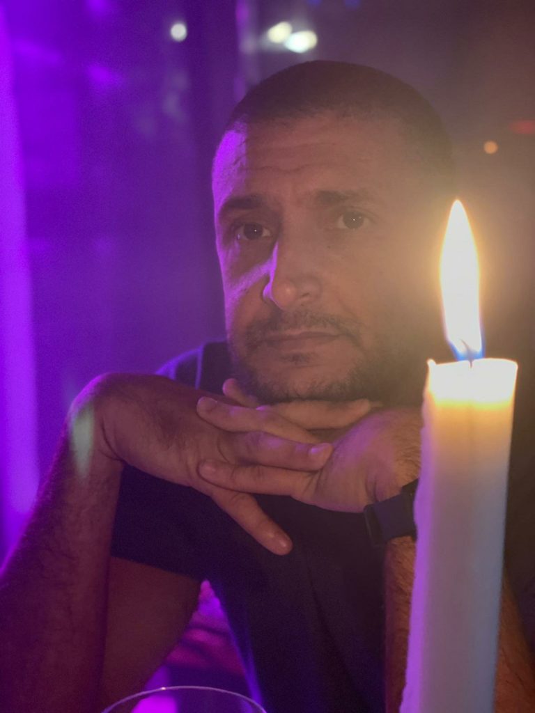 a man sitting at a table with a lit candle