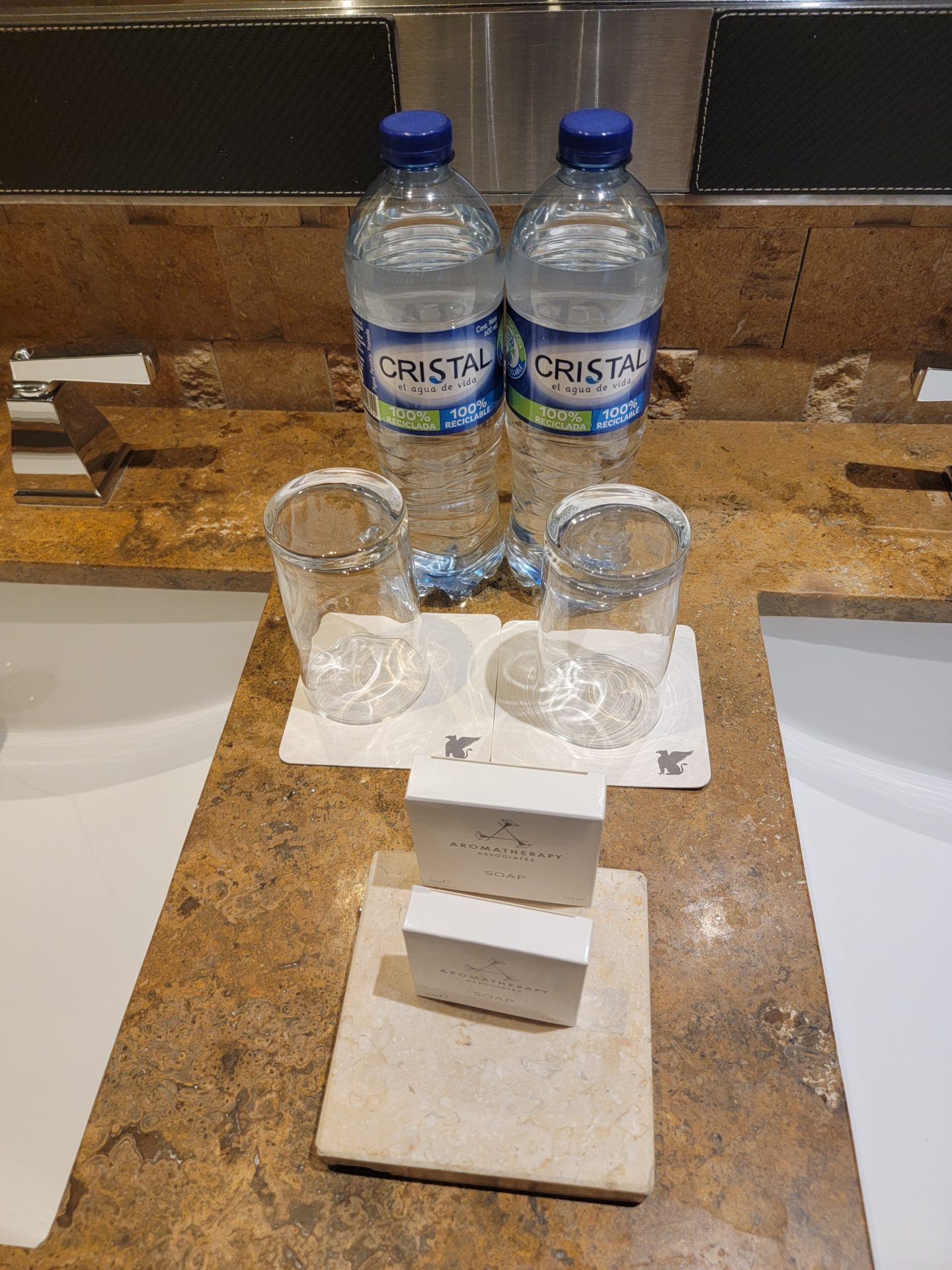 a group of water bottles and glasses on a counter