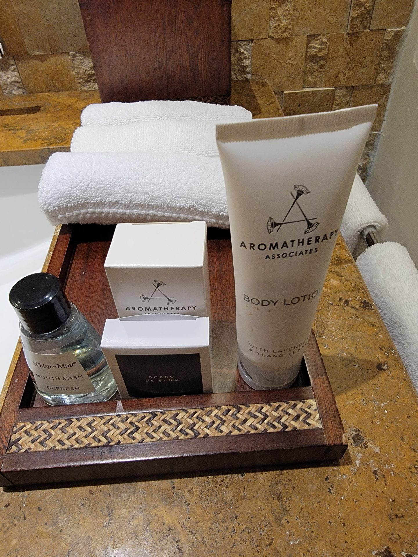 a wooden tray with a group of toiletries and towels