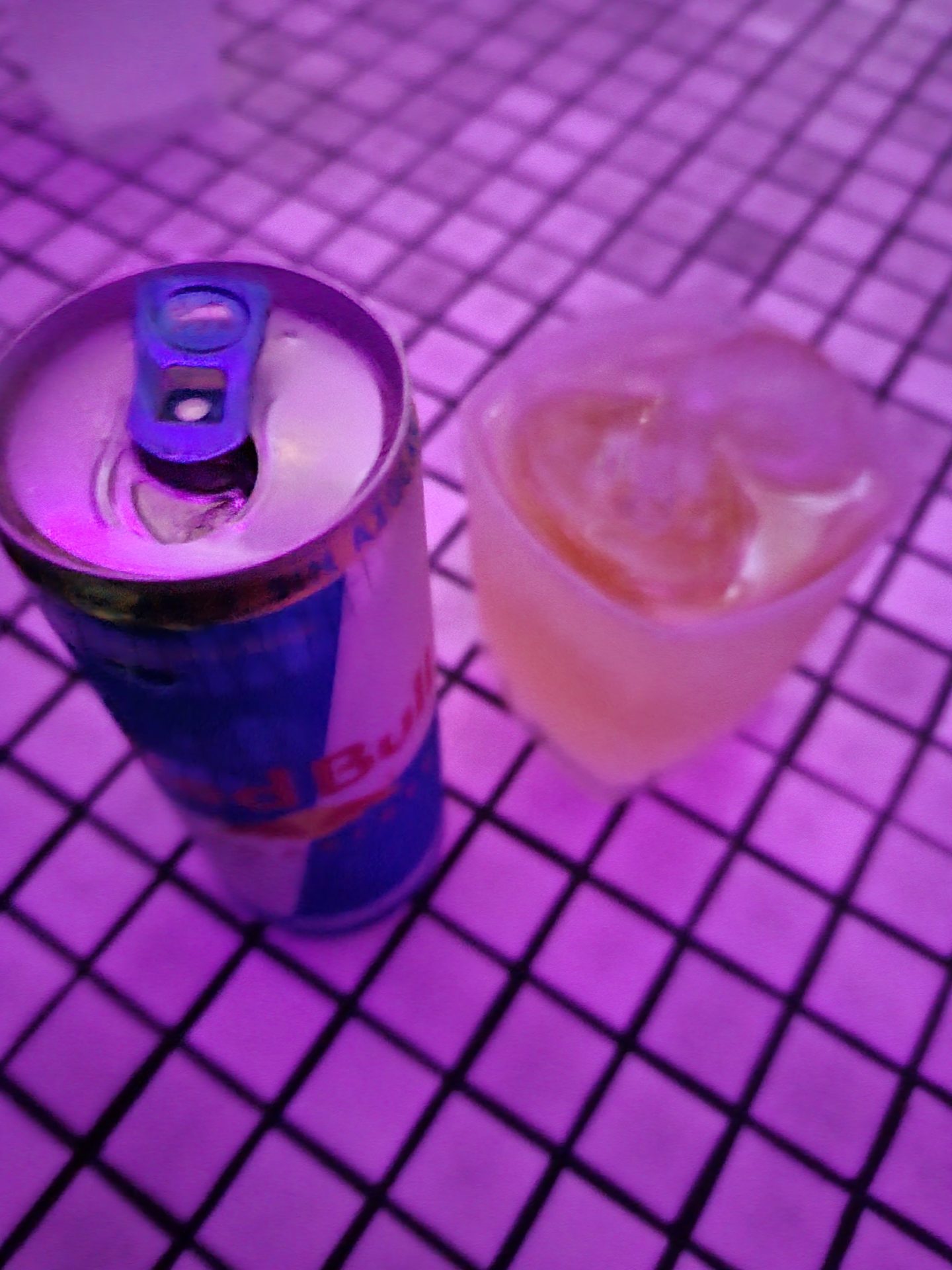 a can and a drink on a tile surface