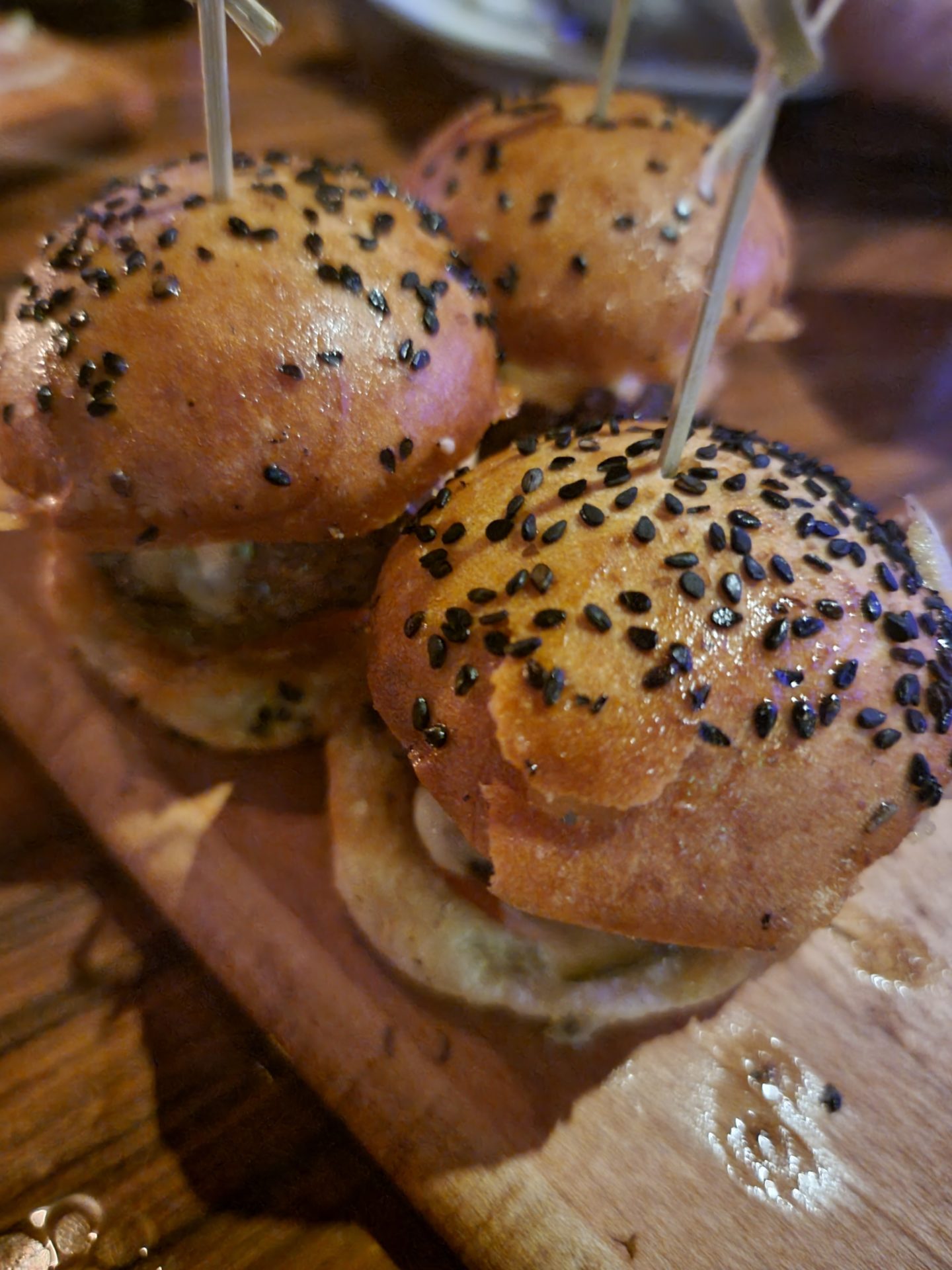 a group of burgers on a wooden board