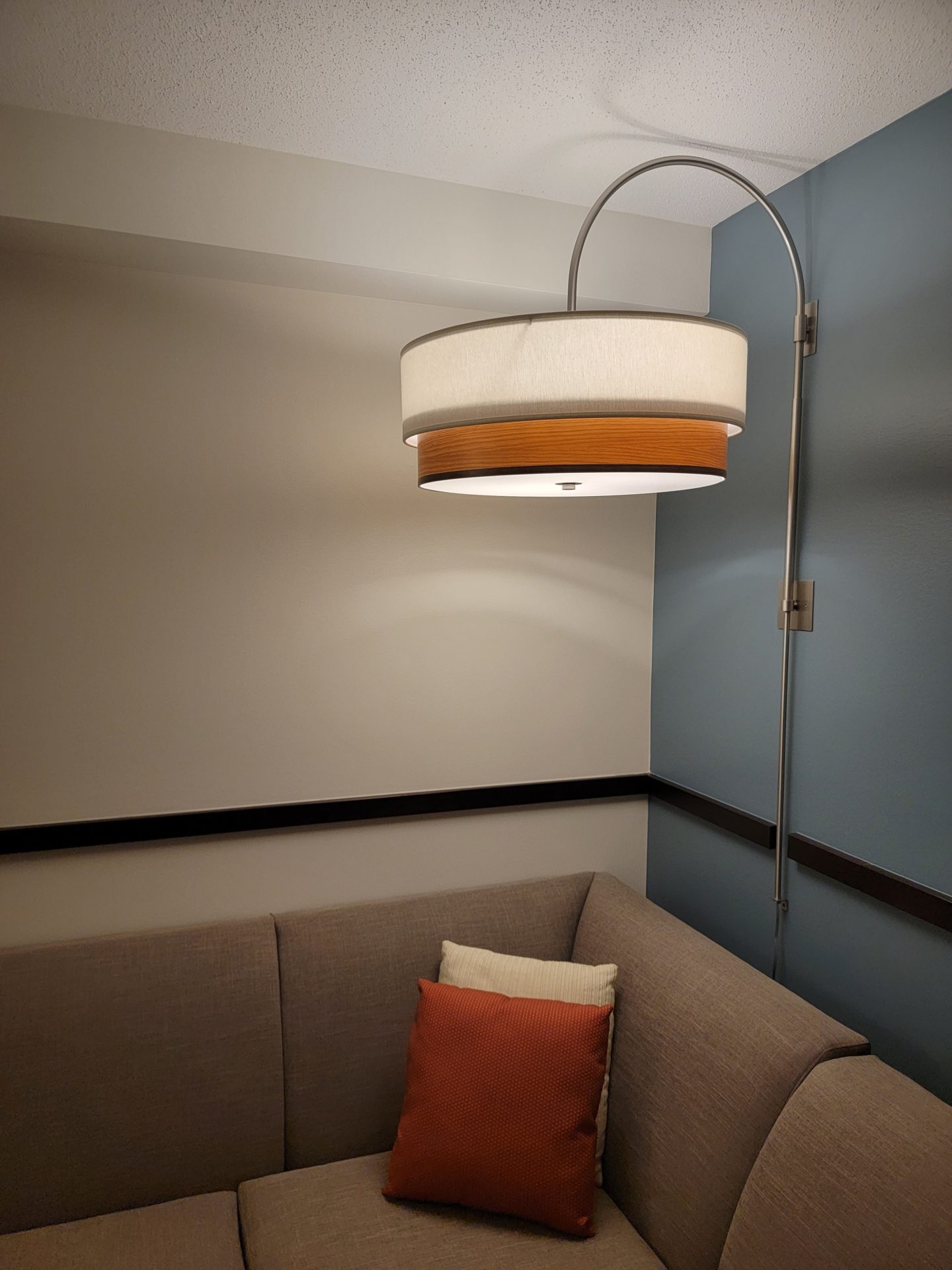 a lamp and pillow in a corner of a room