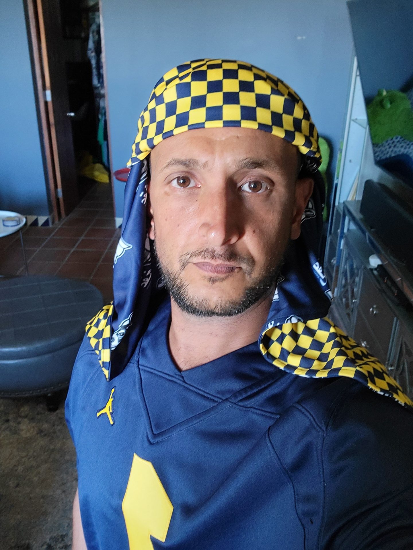 a man wearing a yellow and black checkered head scarf
