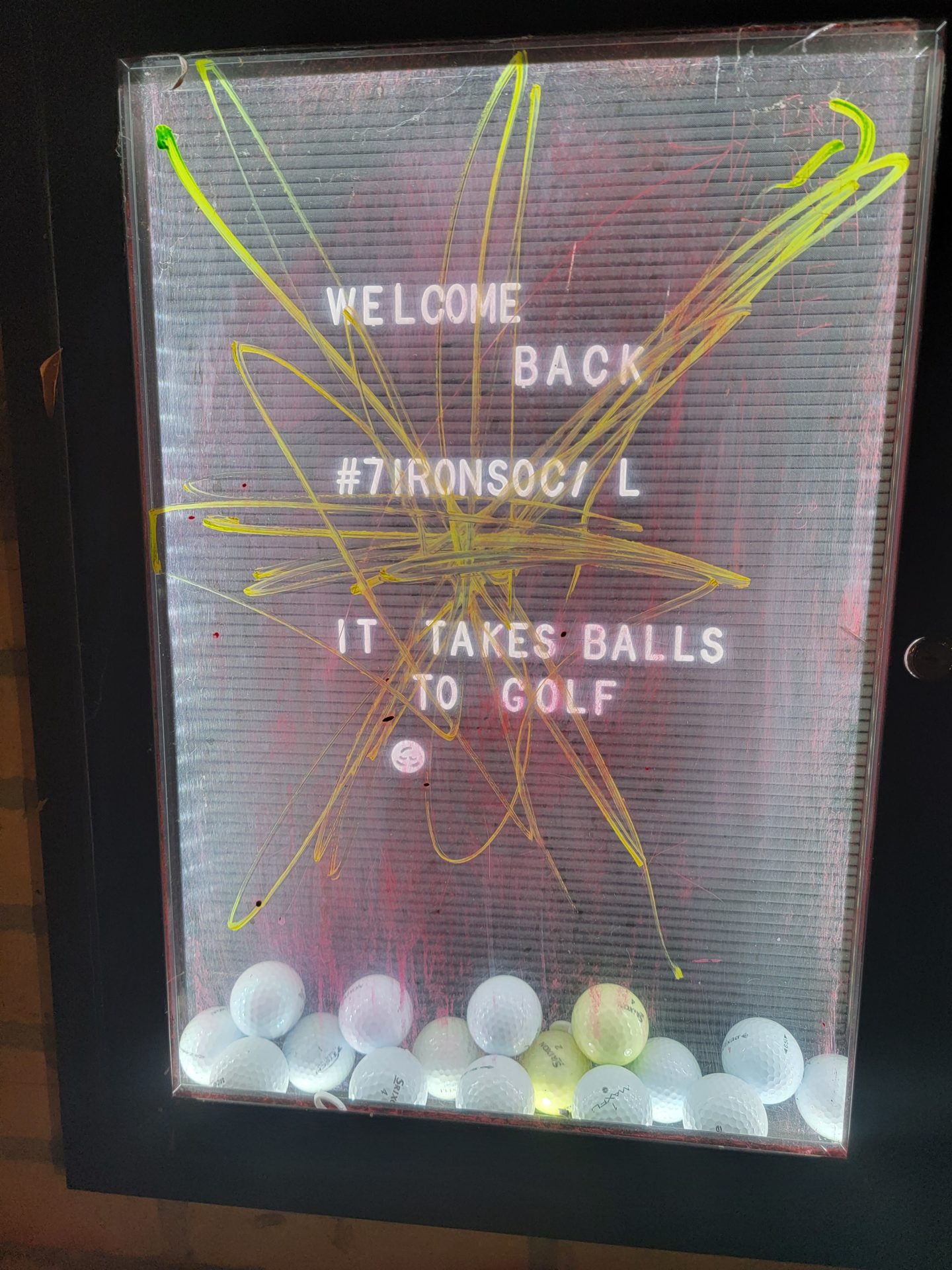 a sign with golf balls and text