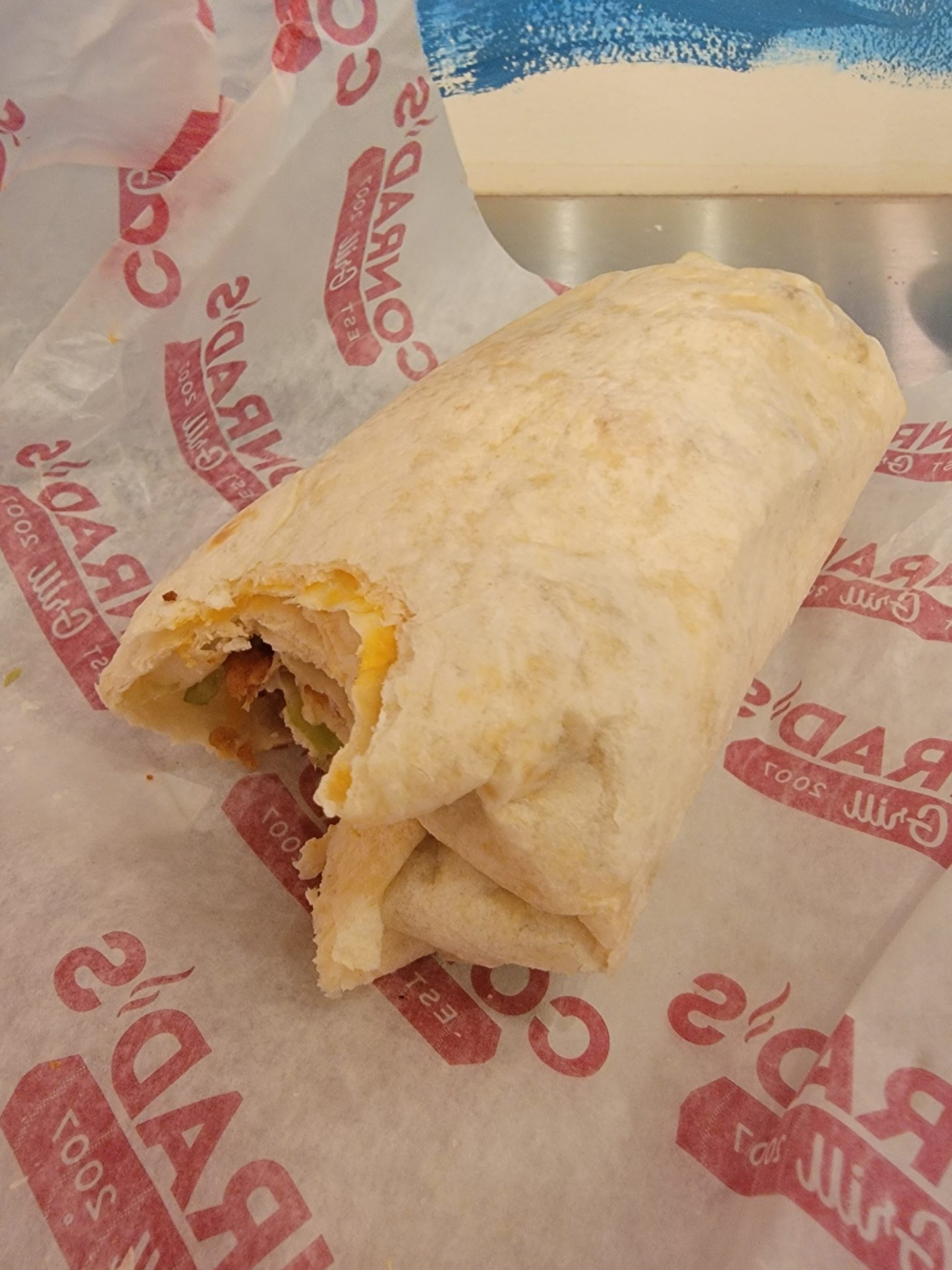 a burrito on a paper wrapper