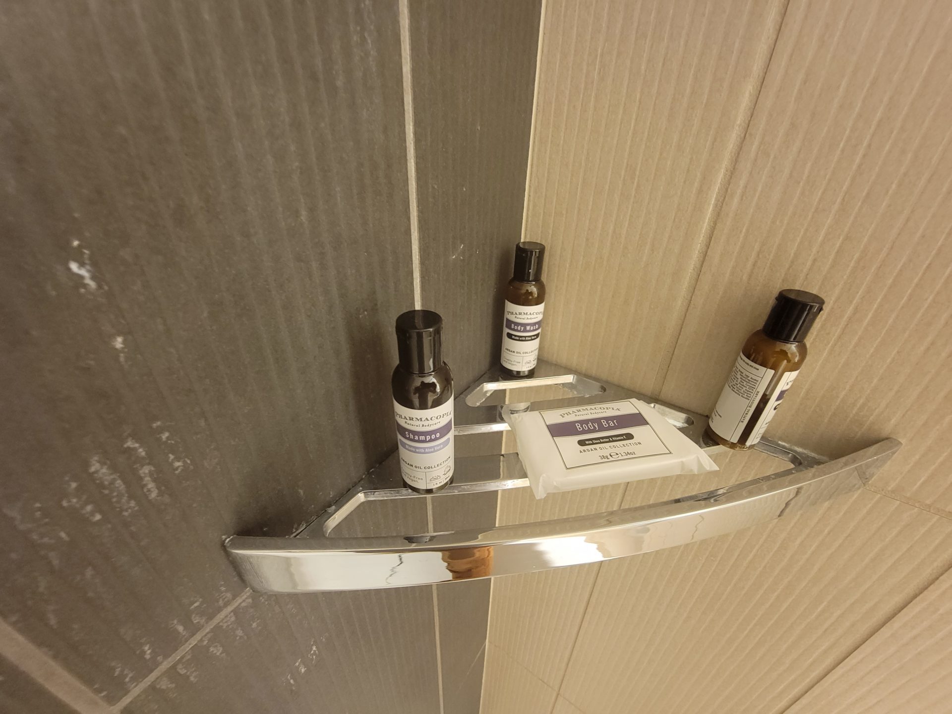 a shower with a shelf and bottles of shampoo