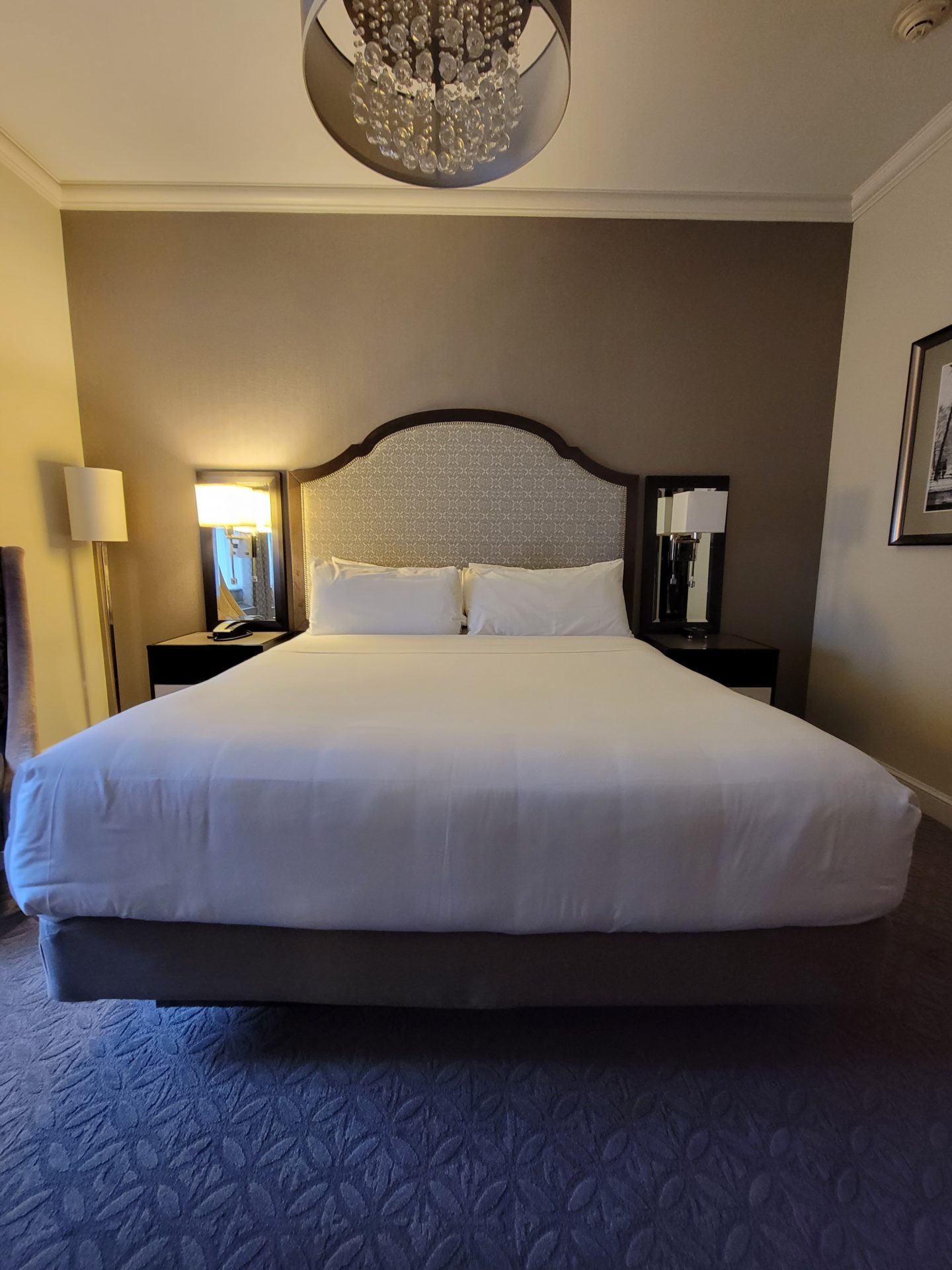 a bed with white sheets and a lamp