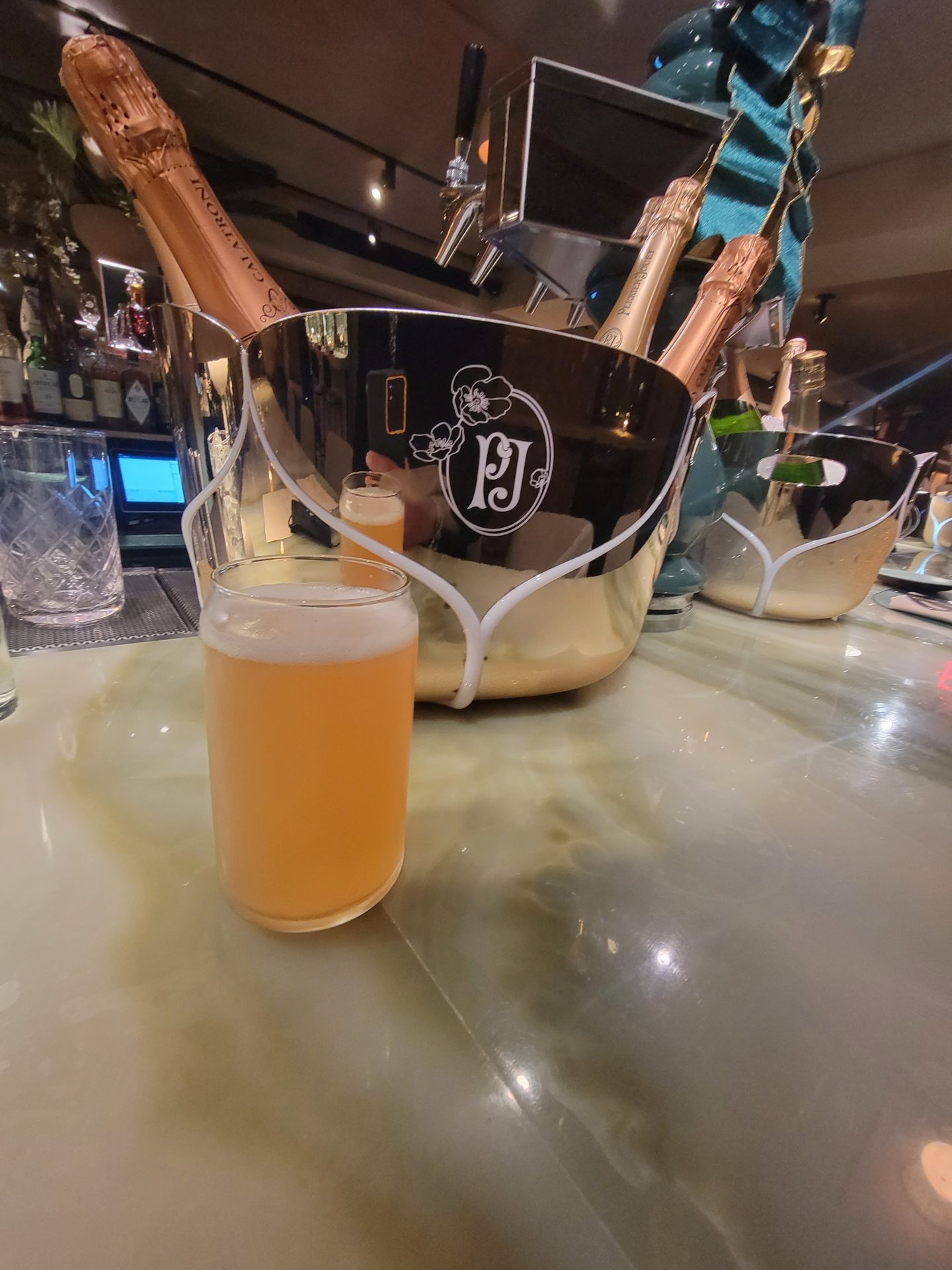 a glass of beer next to a bucket of champagne