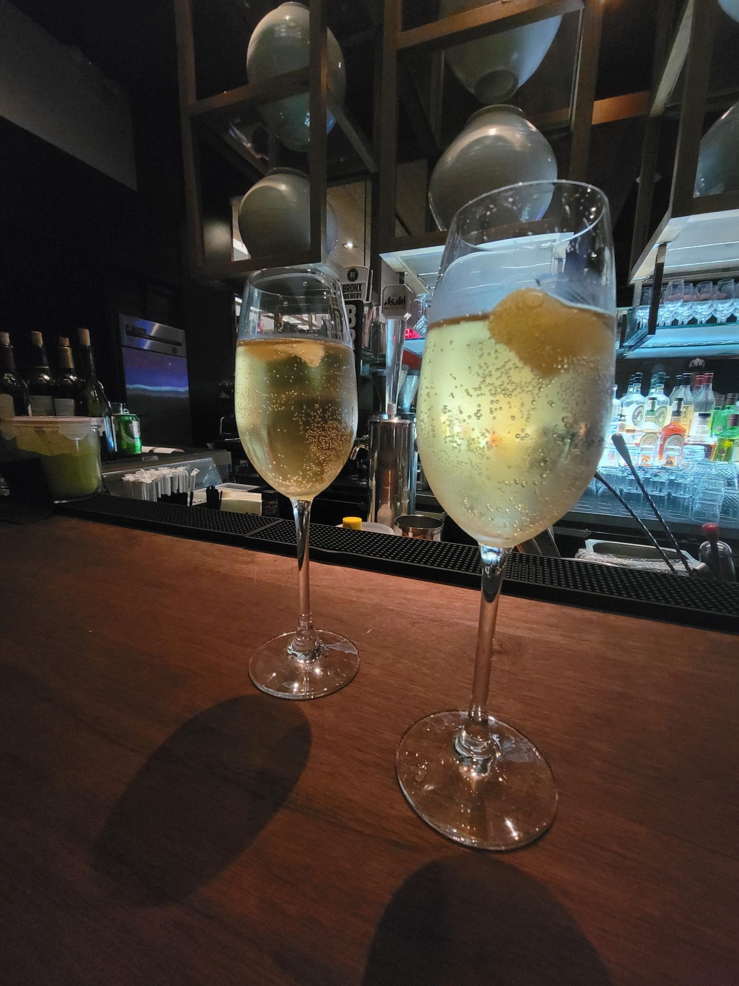two glasses of champagne on a bar