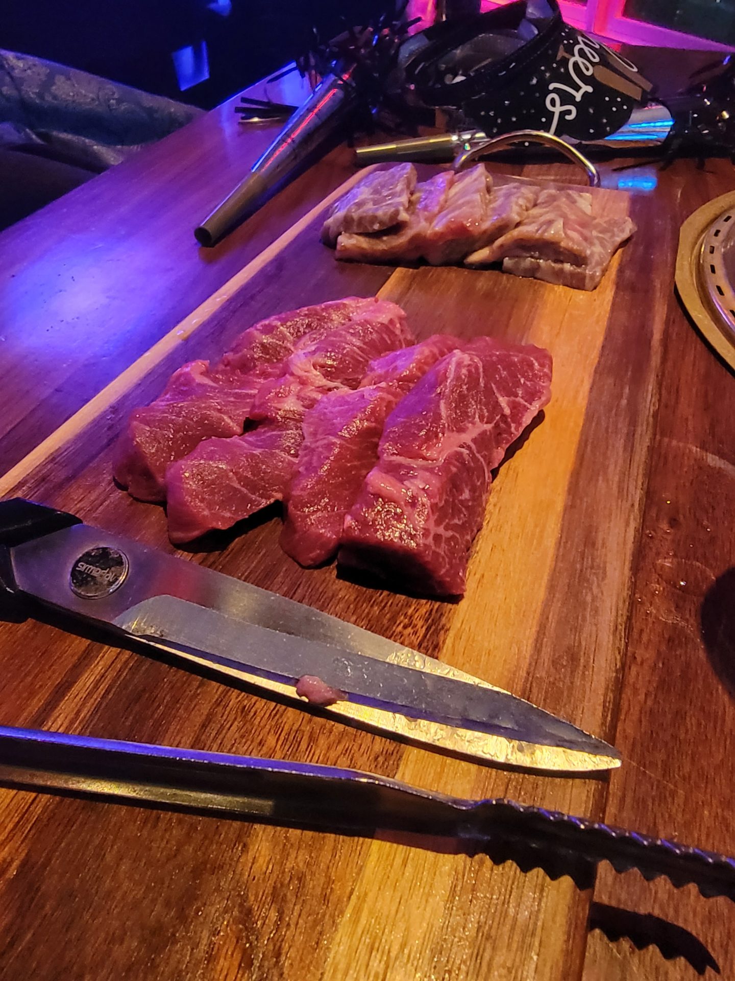 a cutting board with meat and knifes