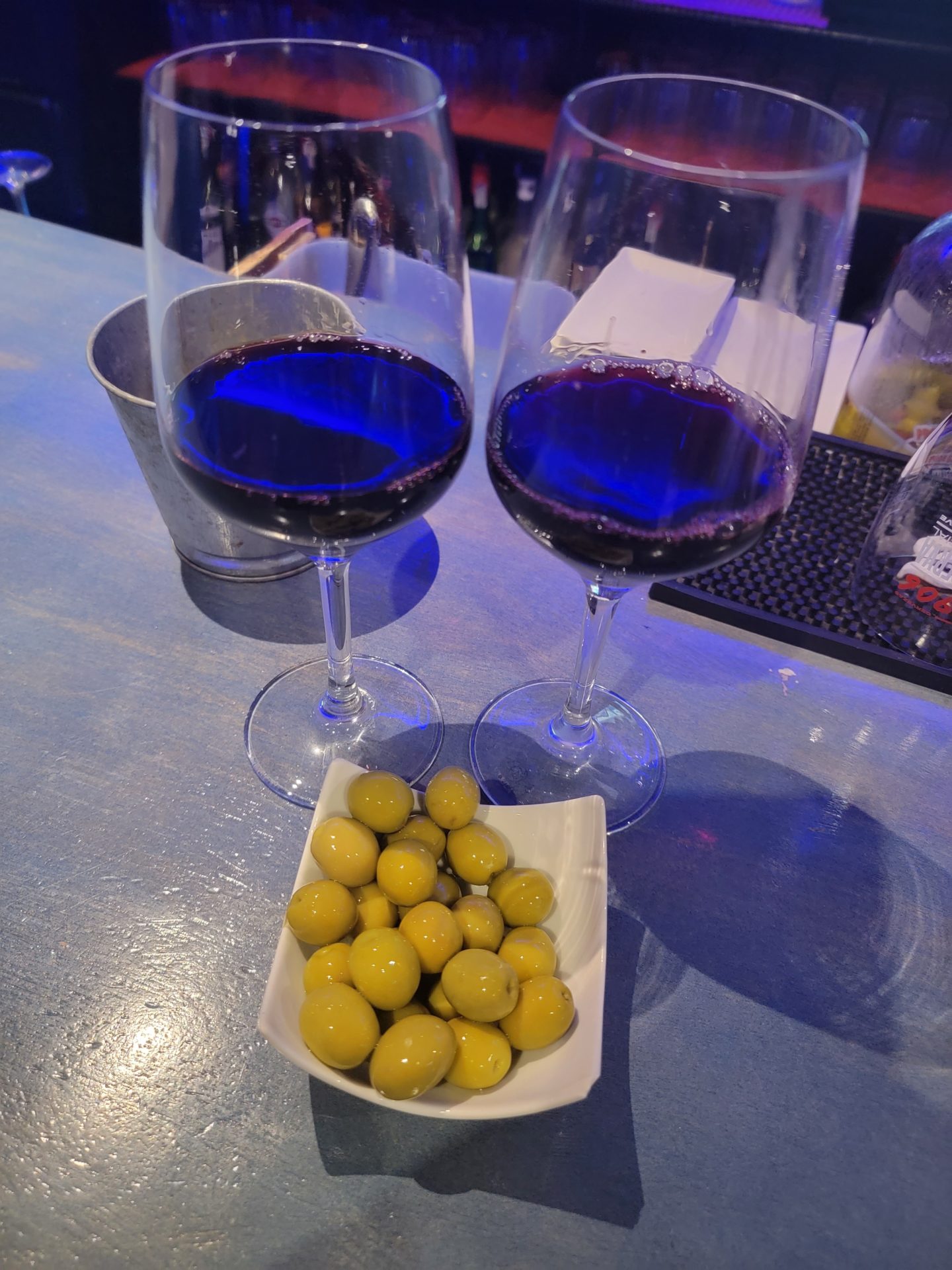 two glasses of wine and a bowl of olives