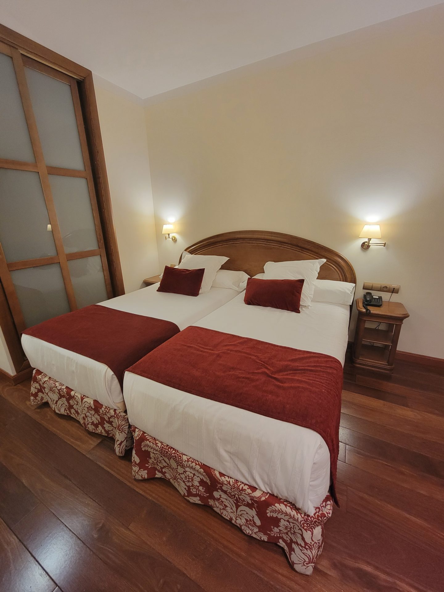 a two beds with red and white pillows