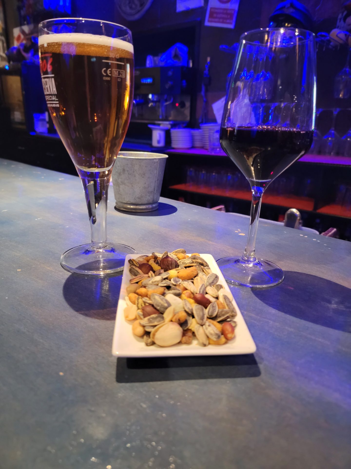 a plate of nuts and a glass of wine