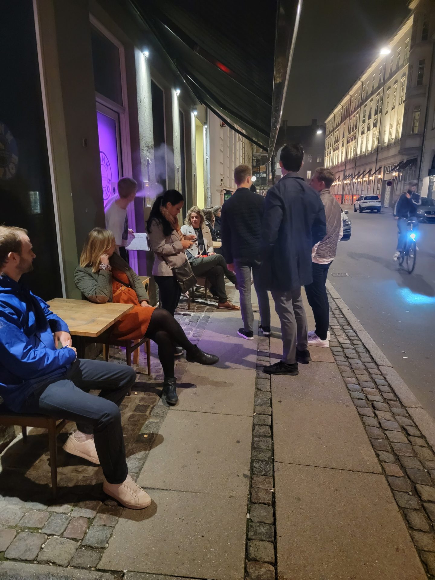 a group of people sitting on a sidewalk
