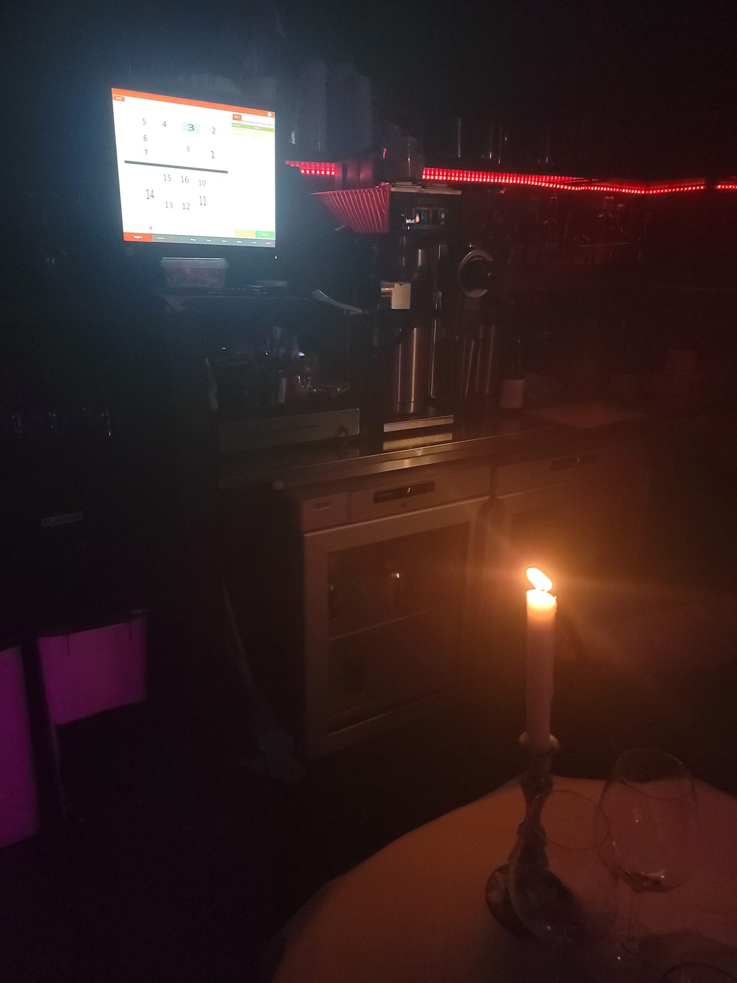 a candle in a glass with a computer on it