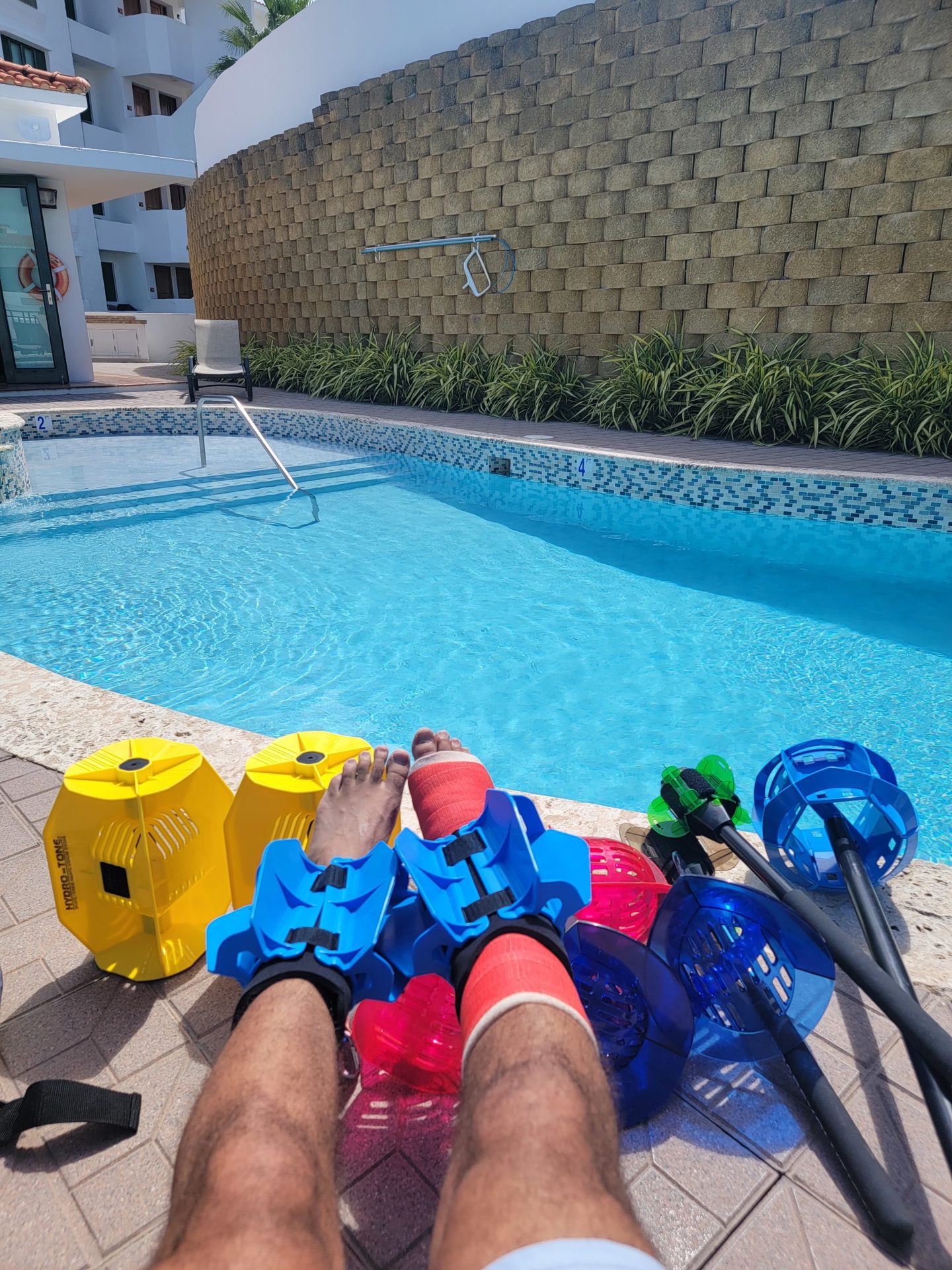 a person's feet with colorful objects next to a pool