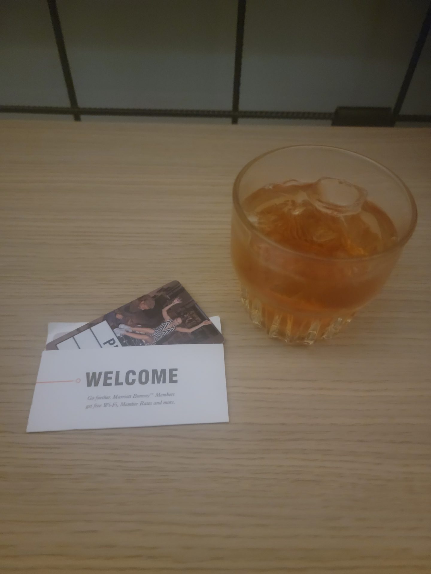 a glass of liquid and a card on a table