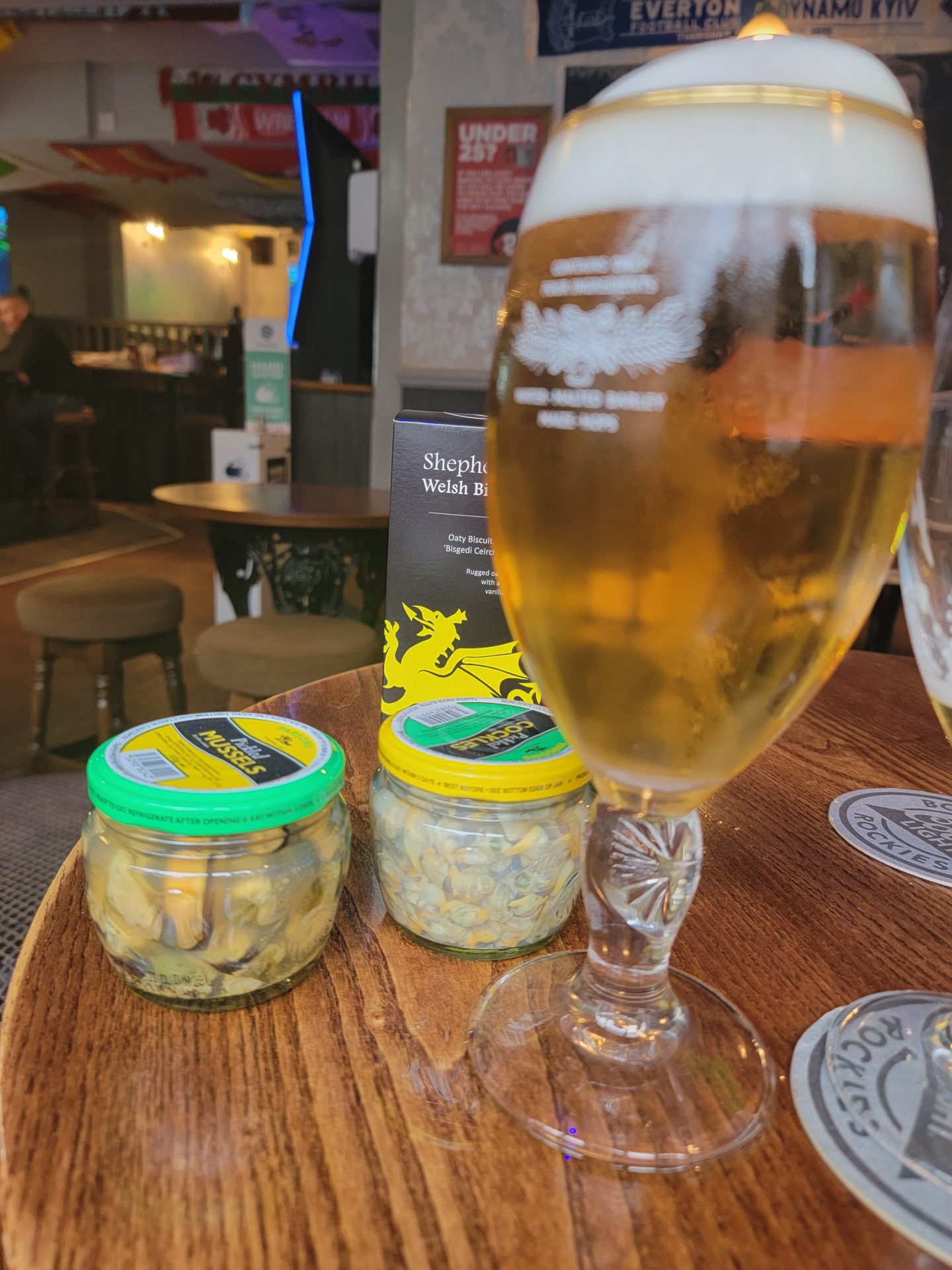 a glass of beer and two jars of food on a table