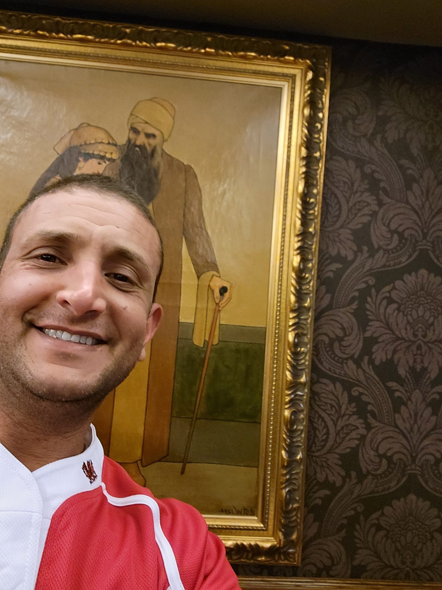 a man taking a selfie in front of a painting