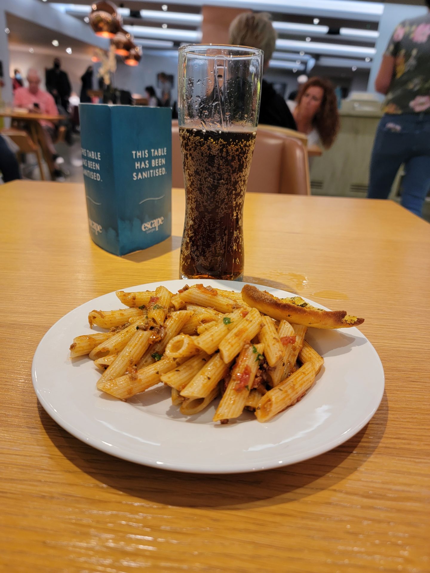 a plate of pasta and a glass of beer on a table