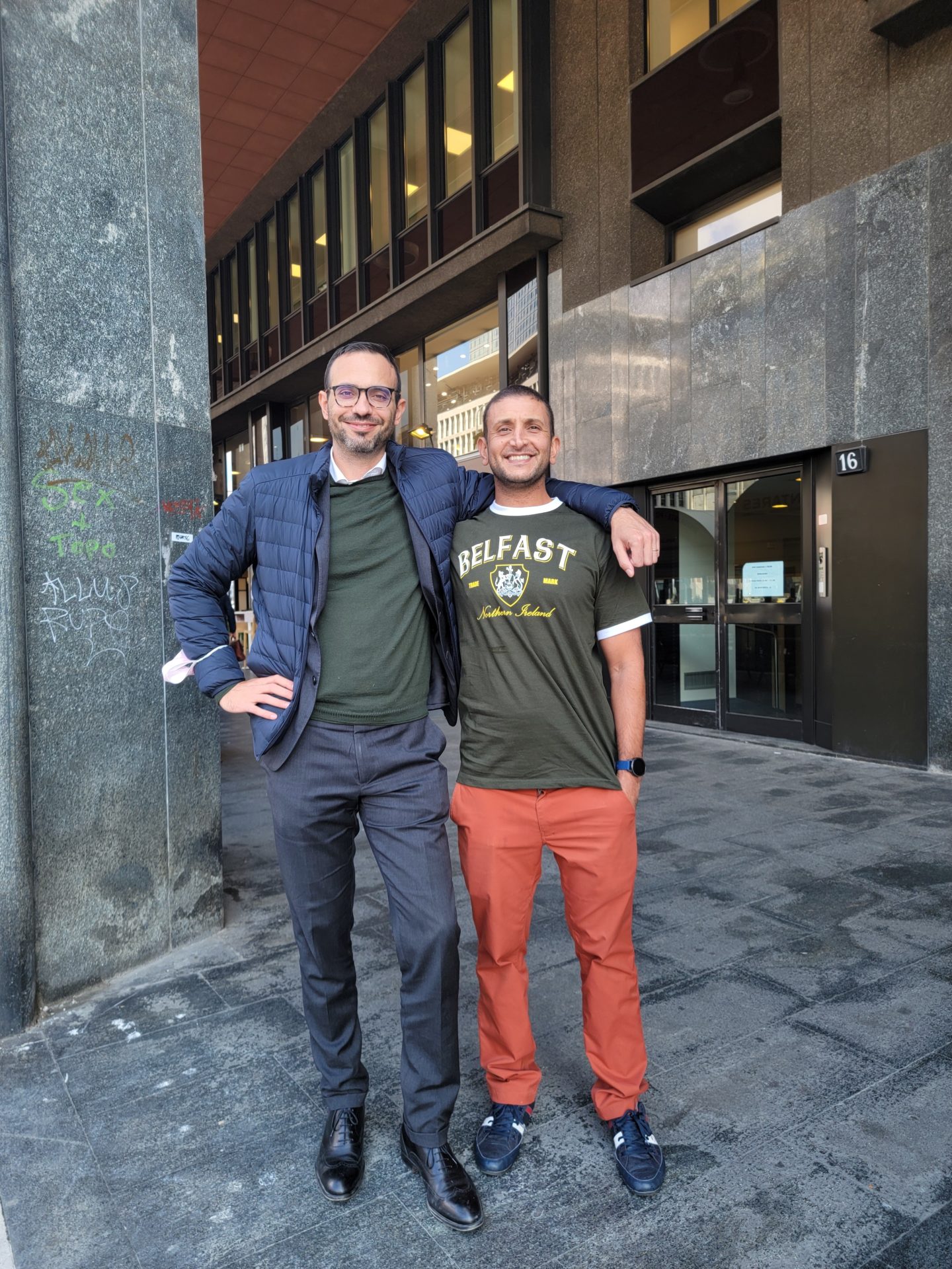 two men standing in front of a building