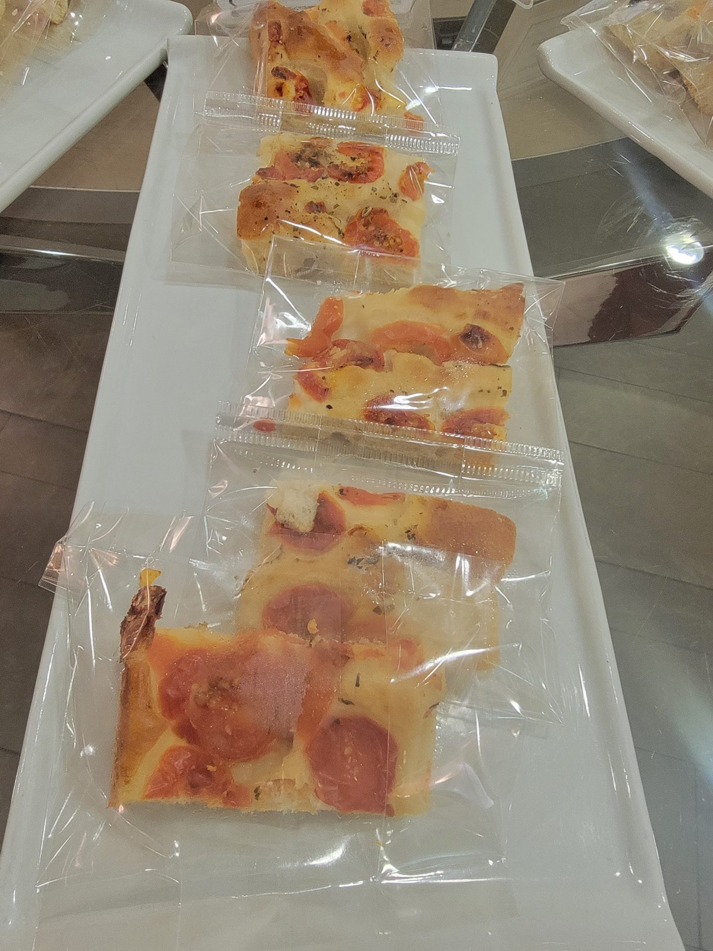 a group of pizzas in plastic bags
