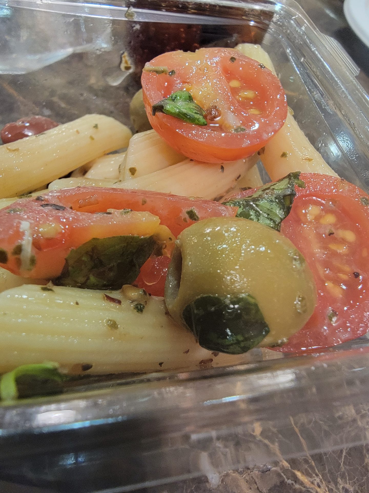 a bowl of pasta with tomatoes and olives