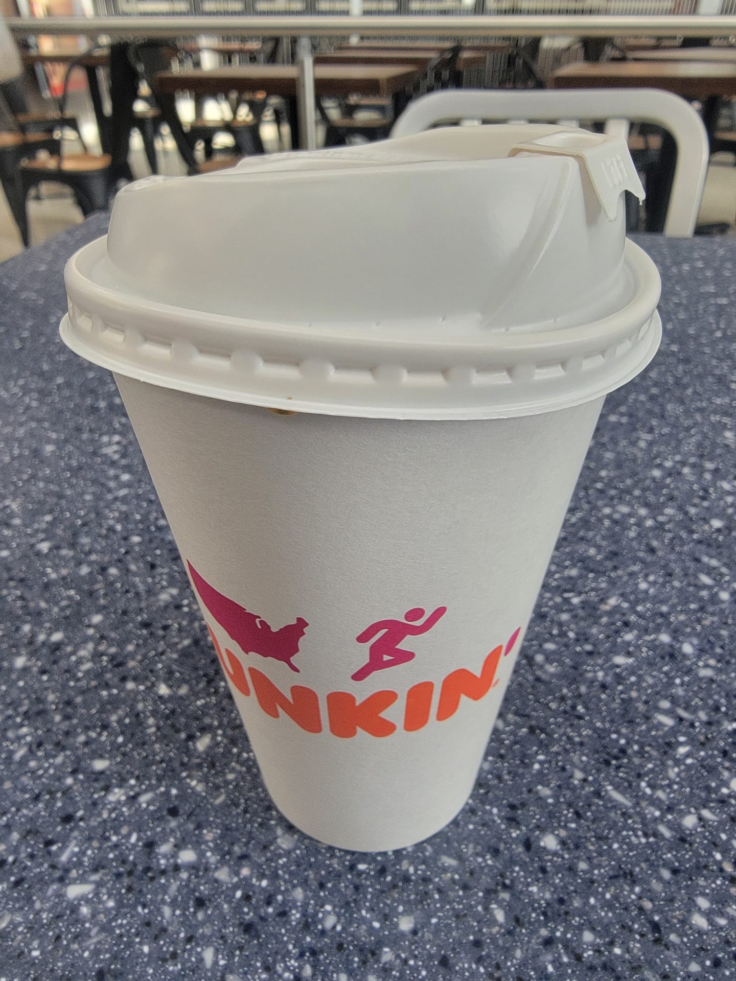a white coffee cup with a lid on a table