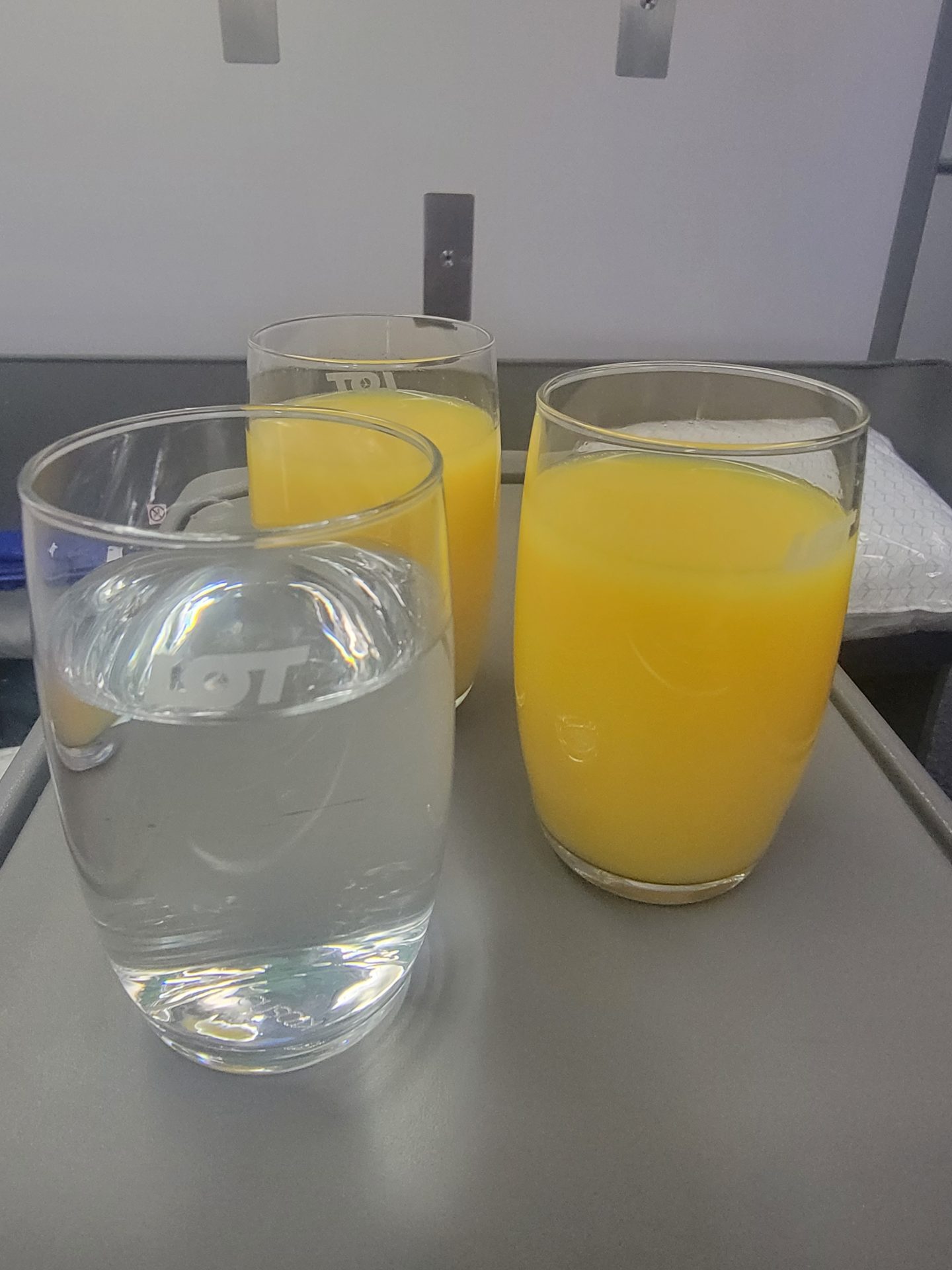 a group of glasses of liquid and a glass of water on a table