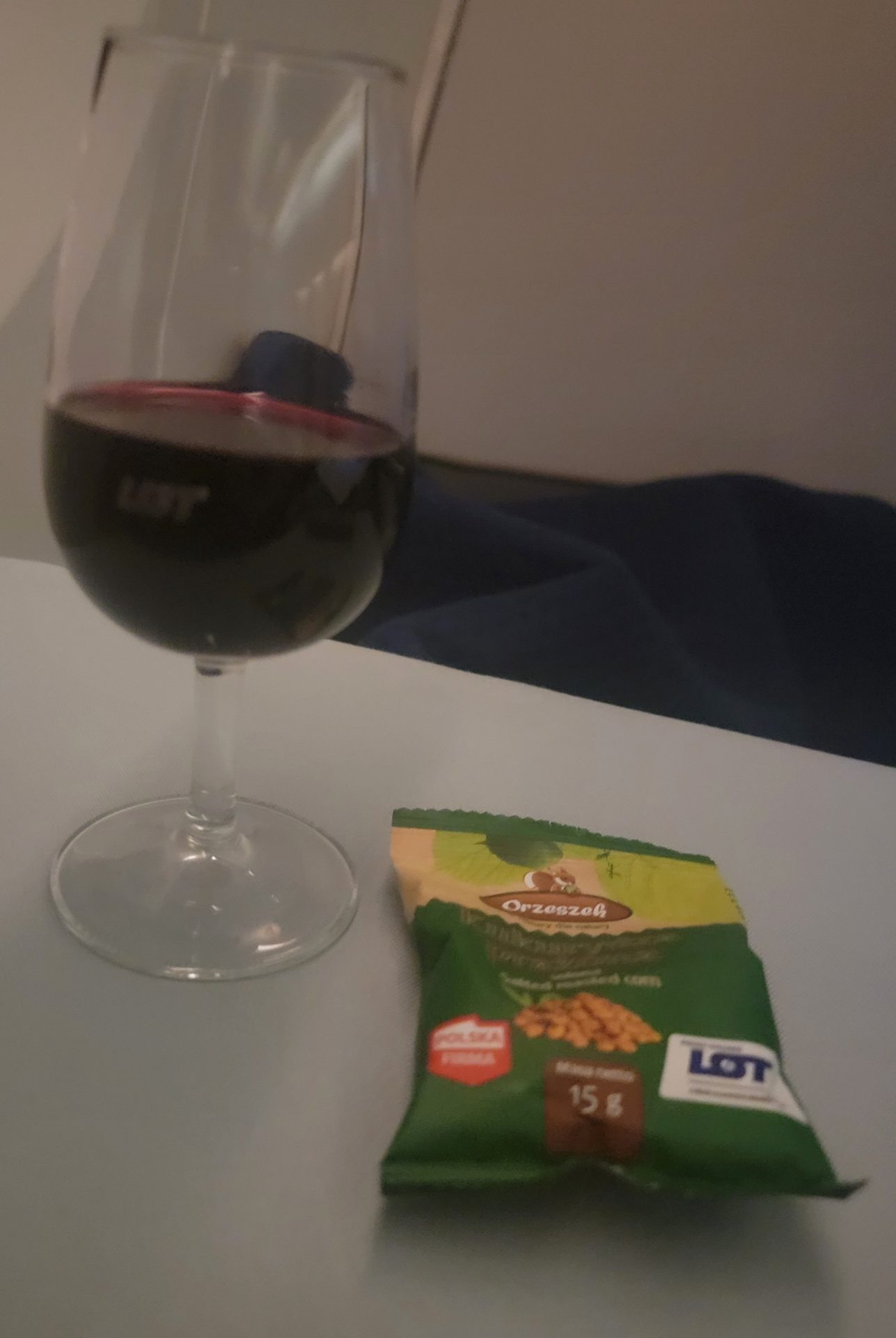 a glass of wine and a packet of snacks