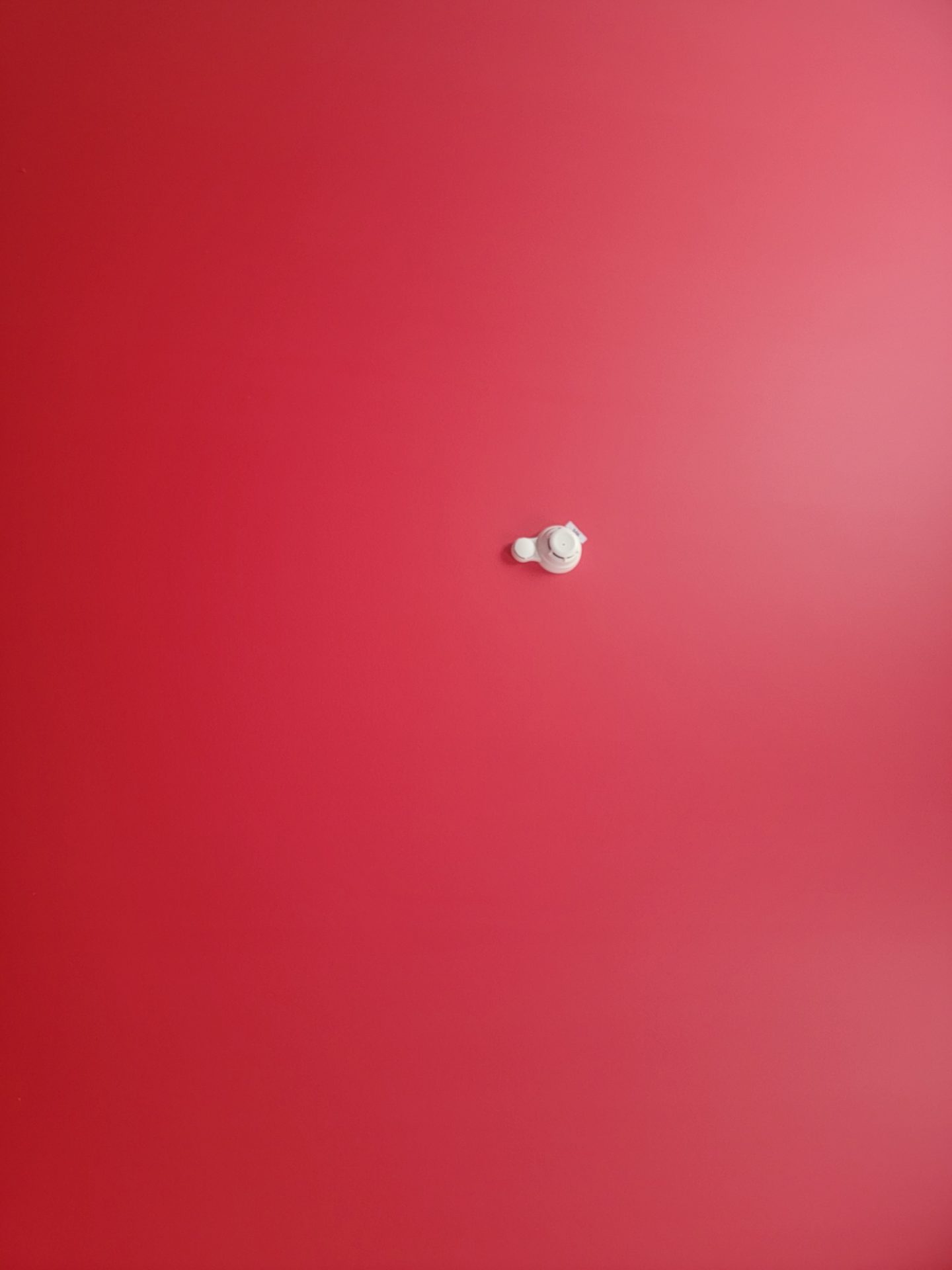 a white object on a red wall