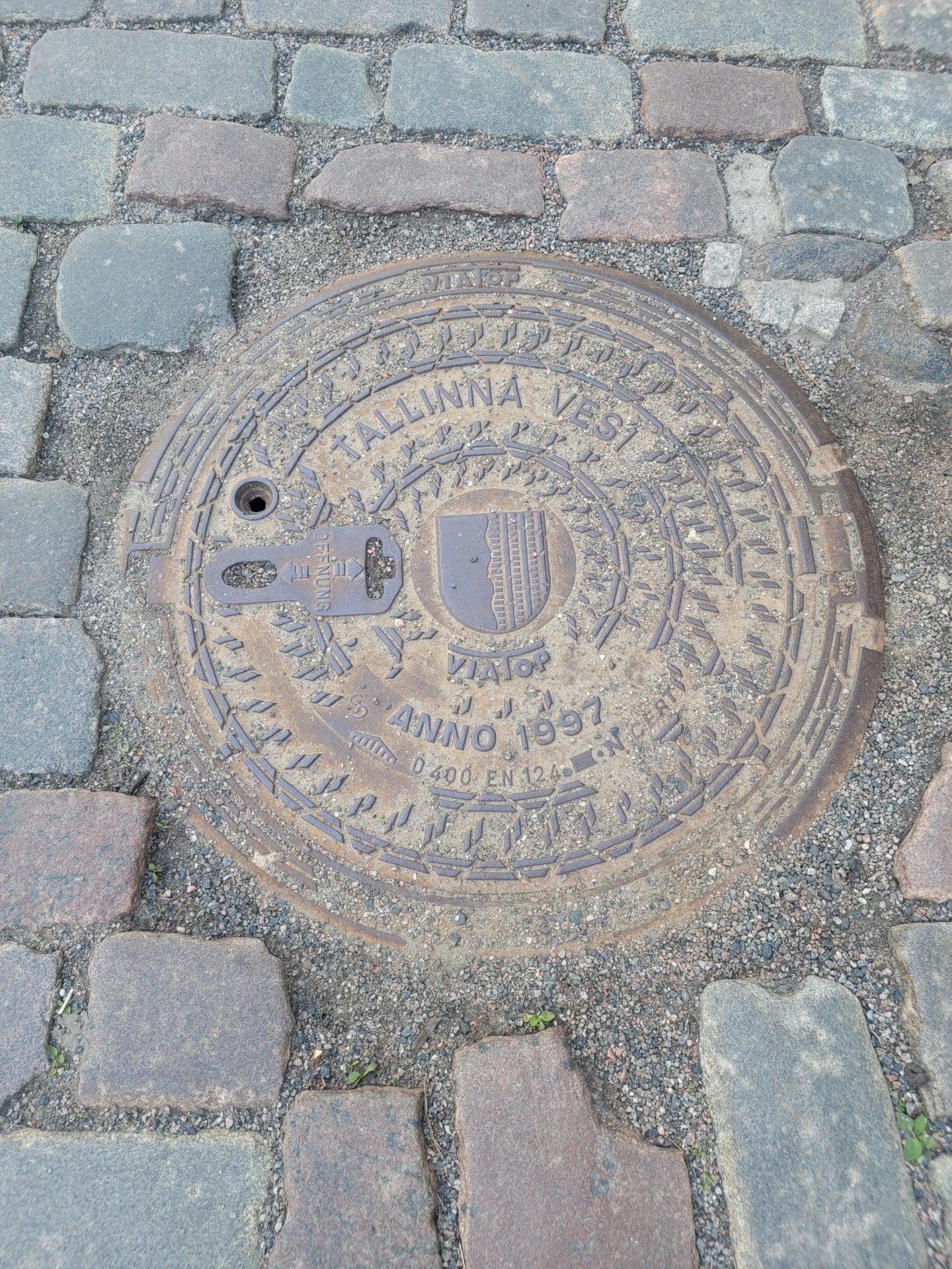 a manhole cover on a cobblestone road
