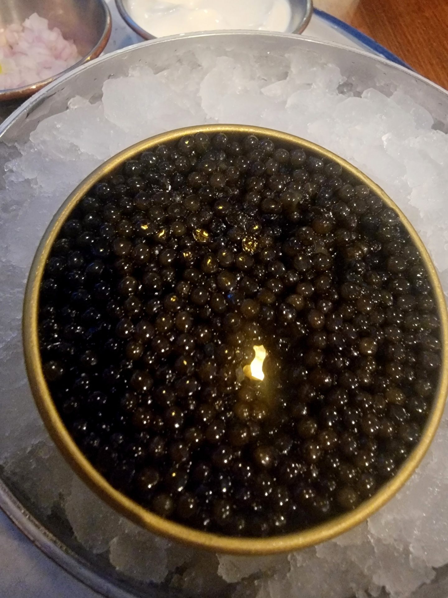 a bowl of black caviar on ice