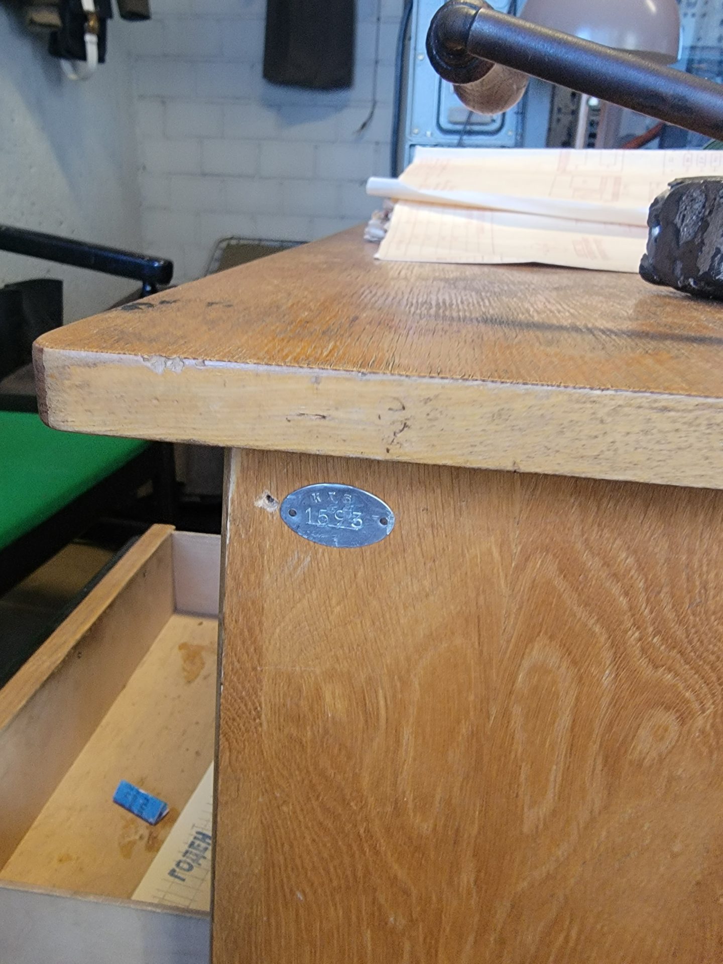 a wooden desk with a metal tag on it