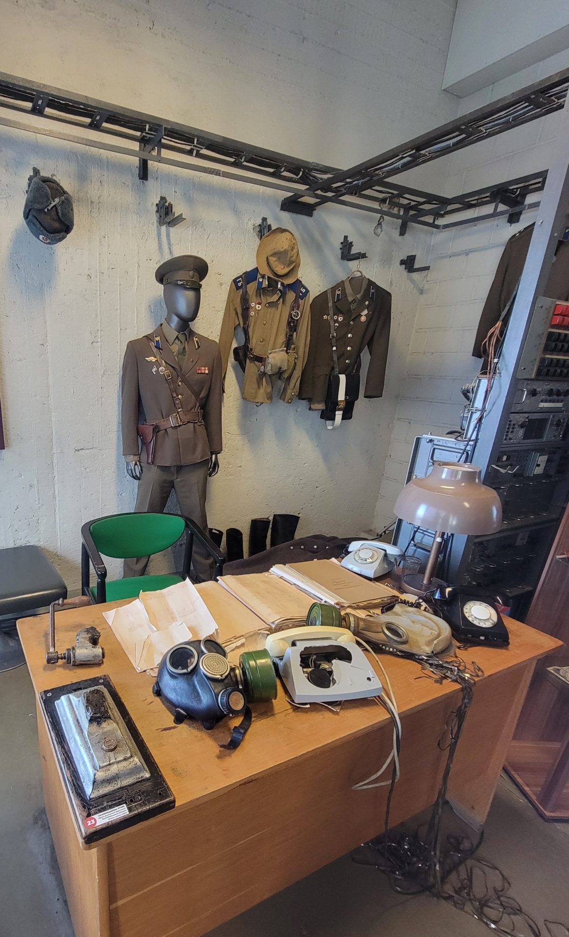 a room with a desk and a table with a mannequin in uniform